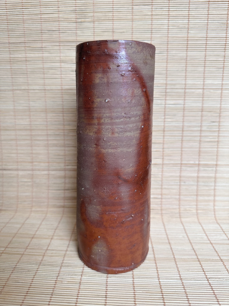 Cylindrical wooden object on a woven mat