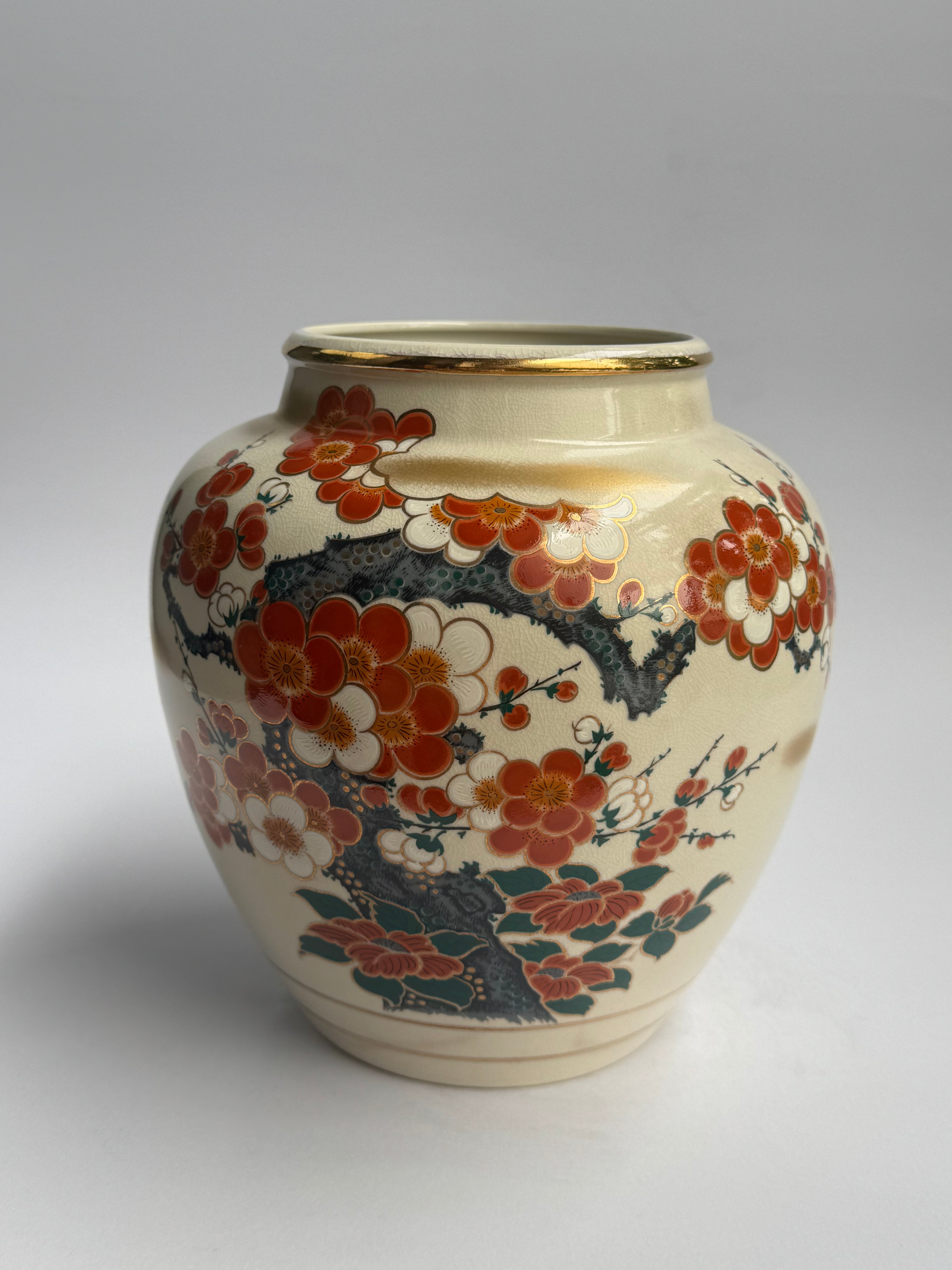 Decorative ceramic vase with floral patterns on a gold background
