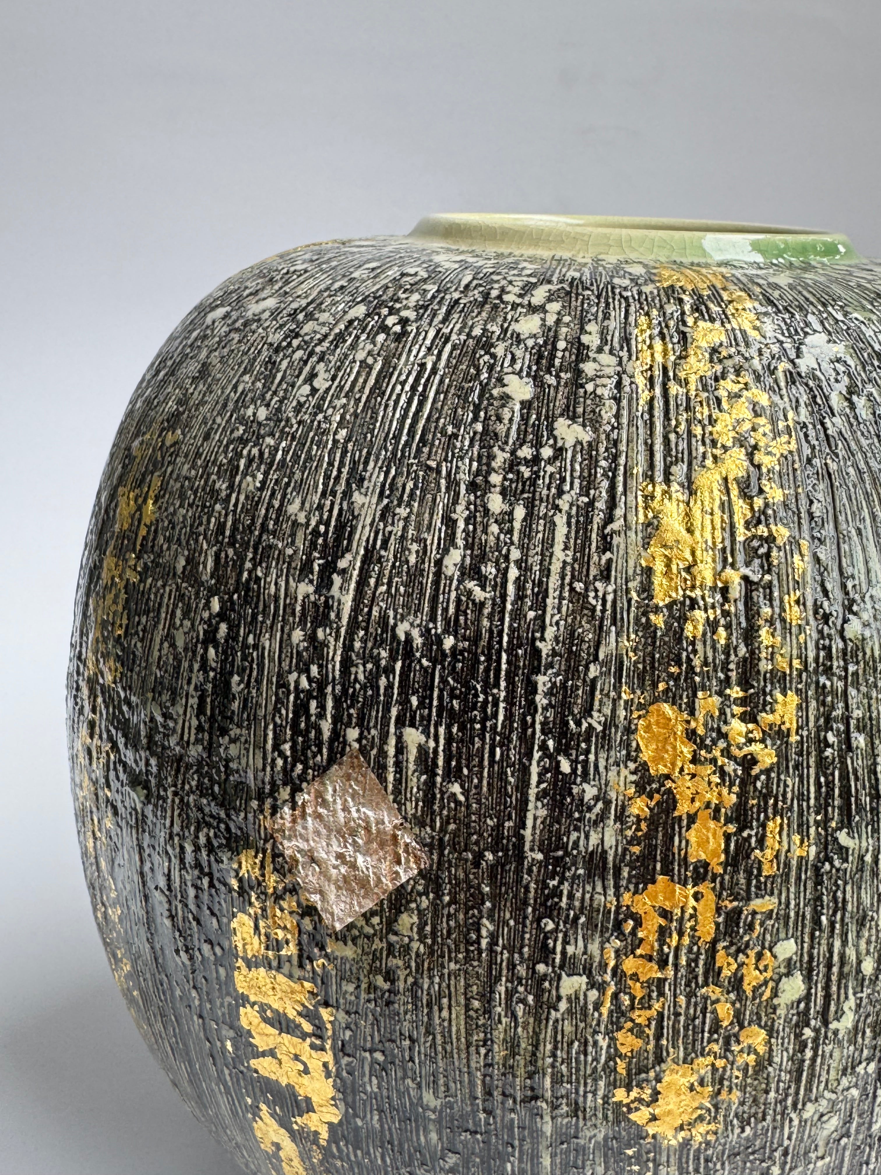 Close-up of a textured surface with gold and silver elements on a gray background