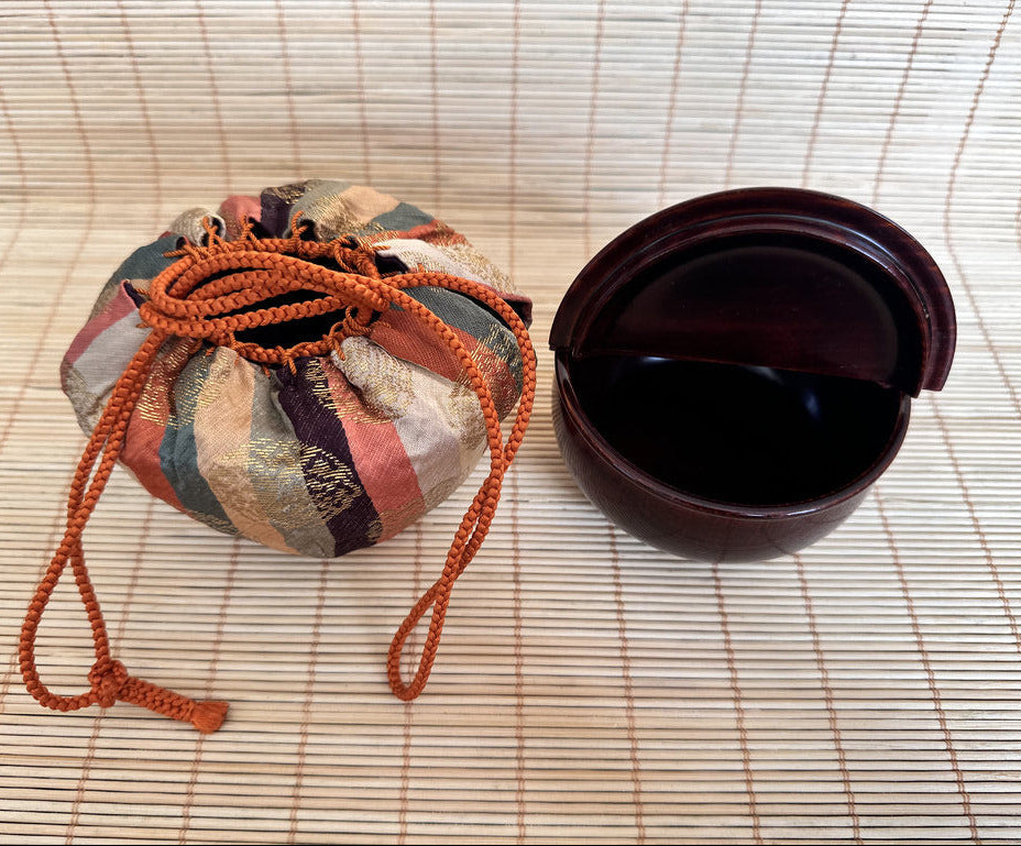 Decorative woven basket with a lid on a textured surface