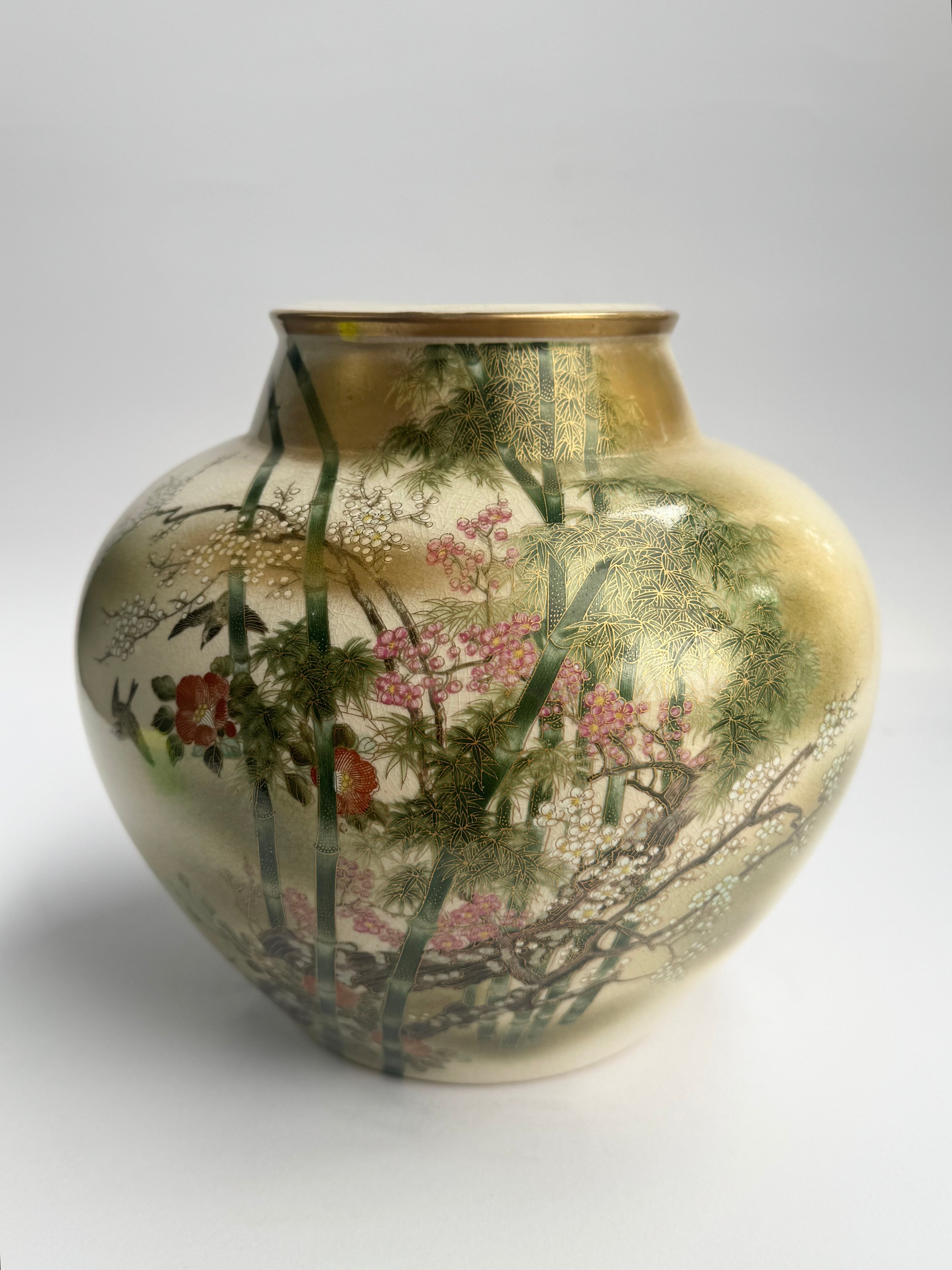 Decorative vase with floral and landscape design on a gold background