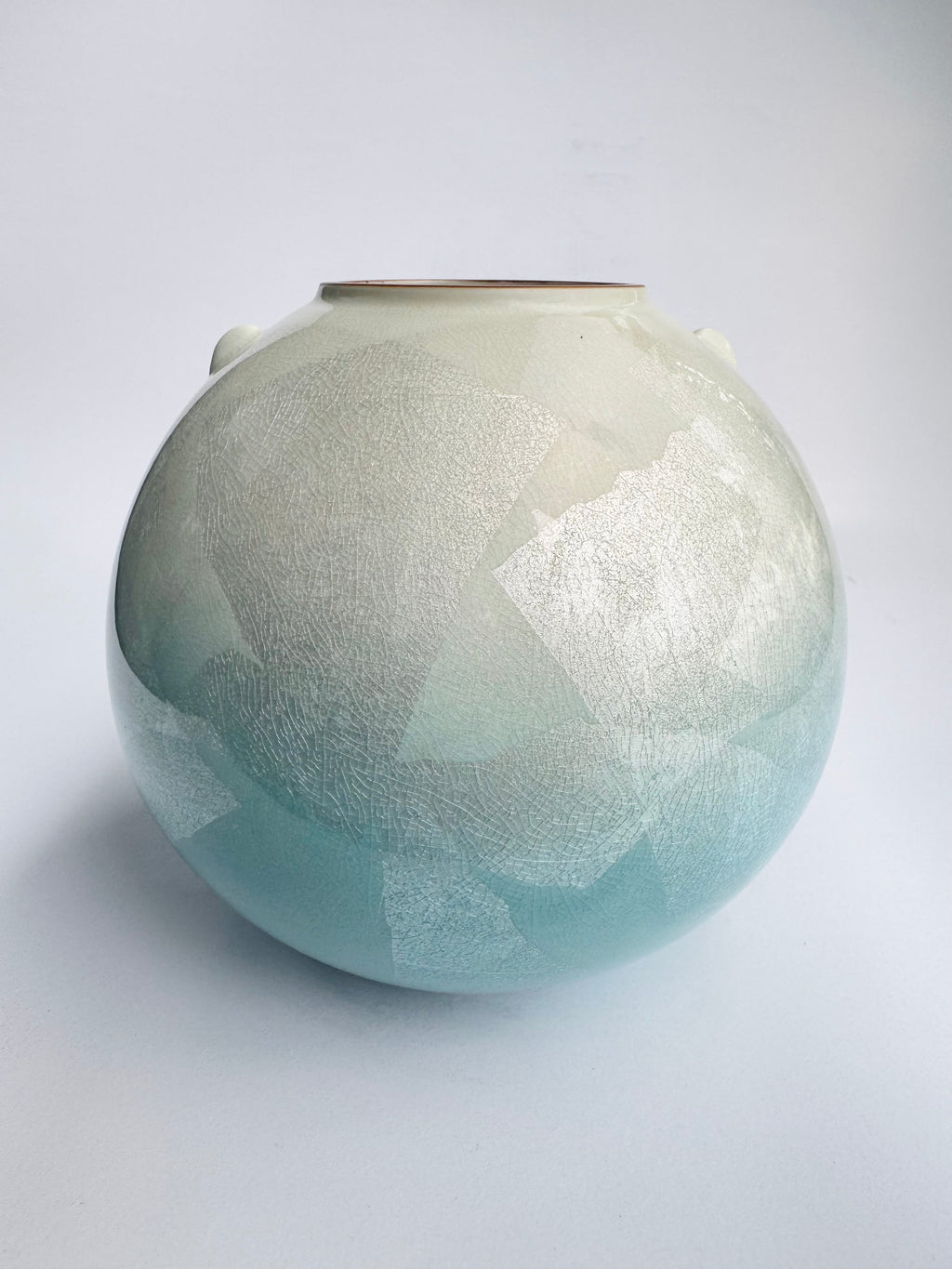 Round ceramic vase with textured surface on a white background