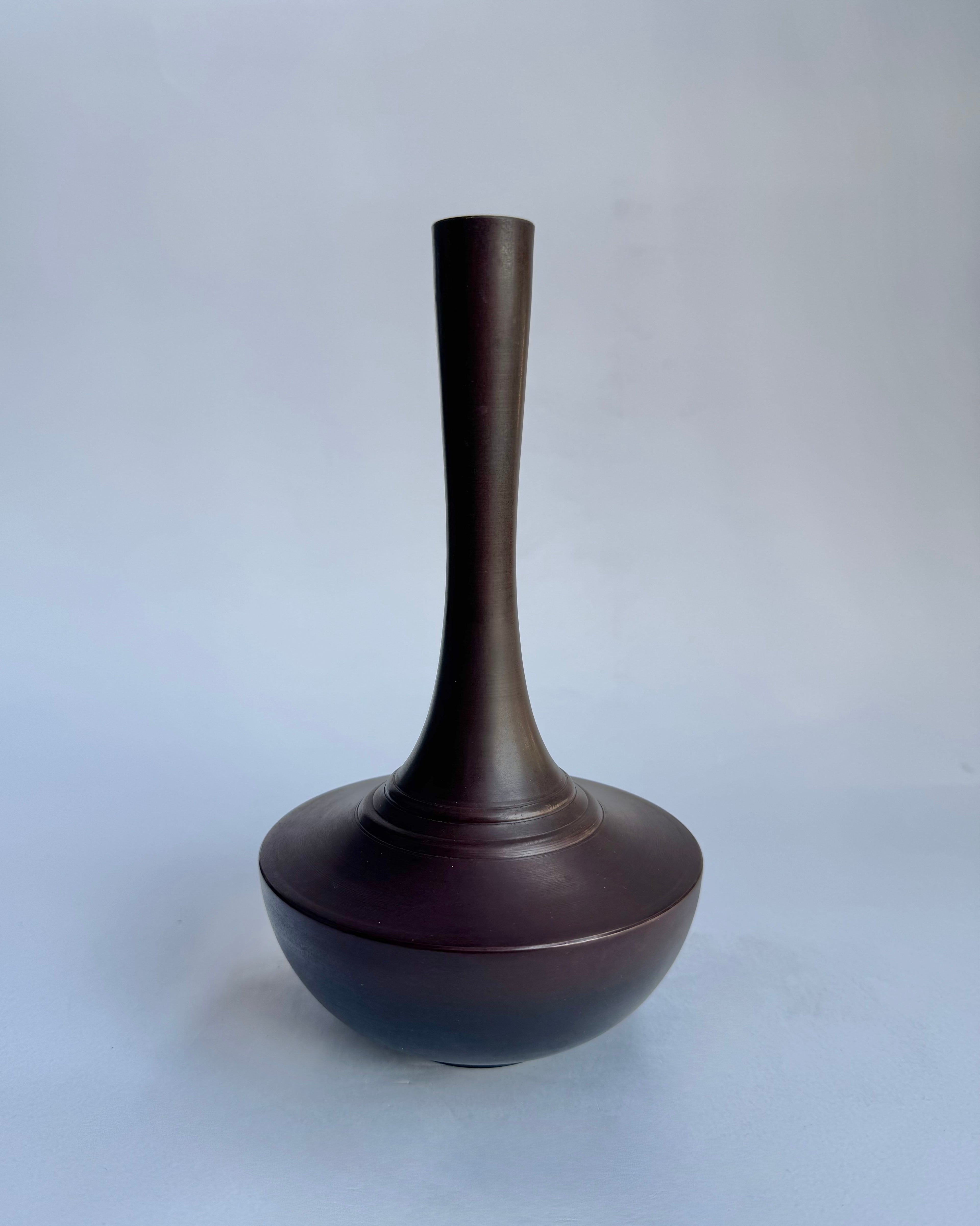 Dark brown vase on a light gray background
