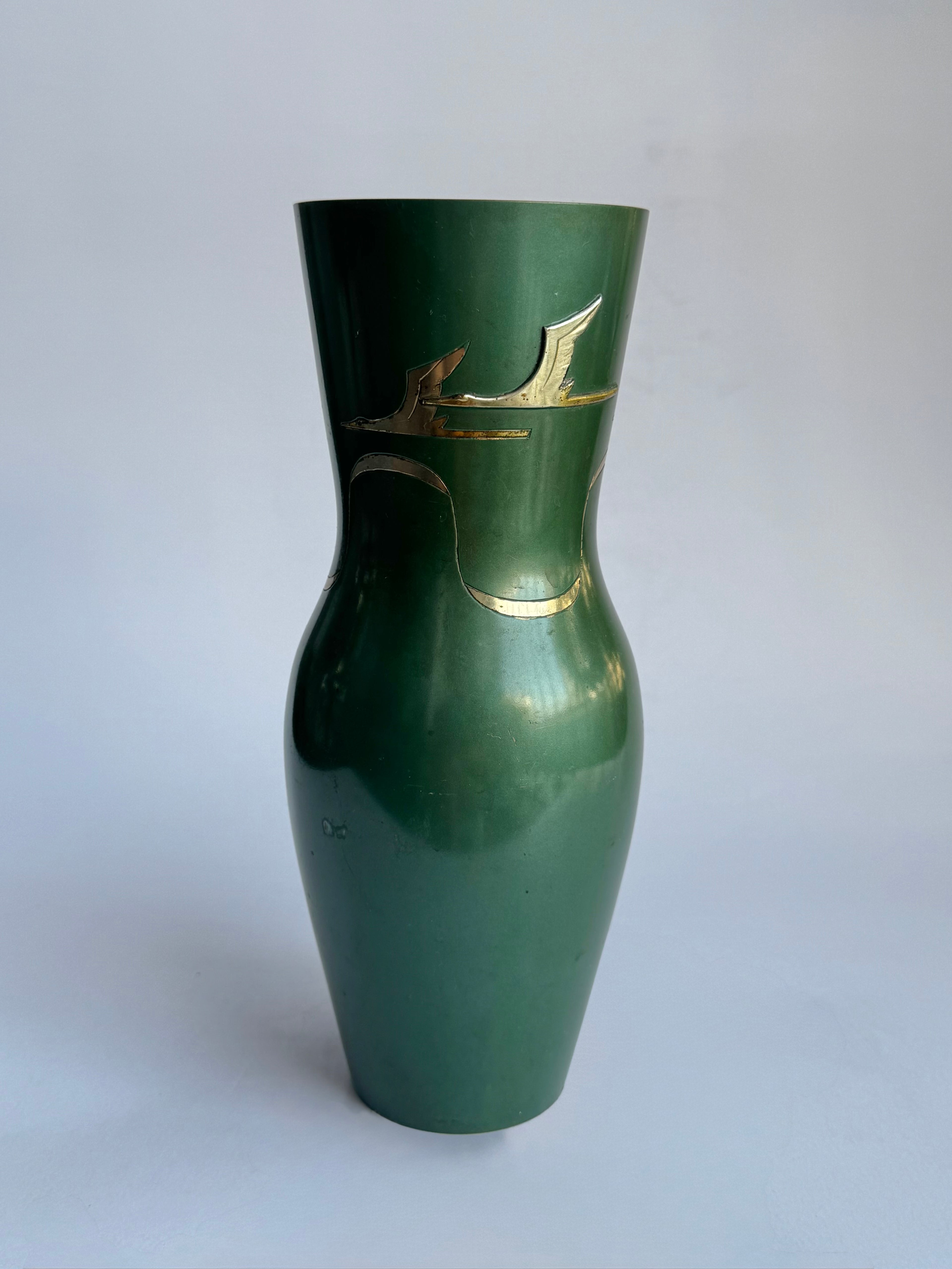 Green vase with gold decorative elements on a white background