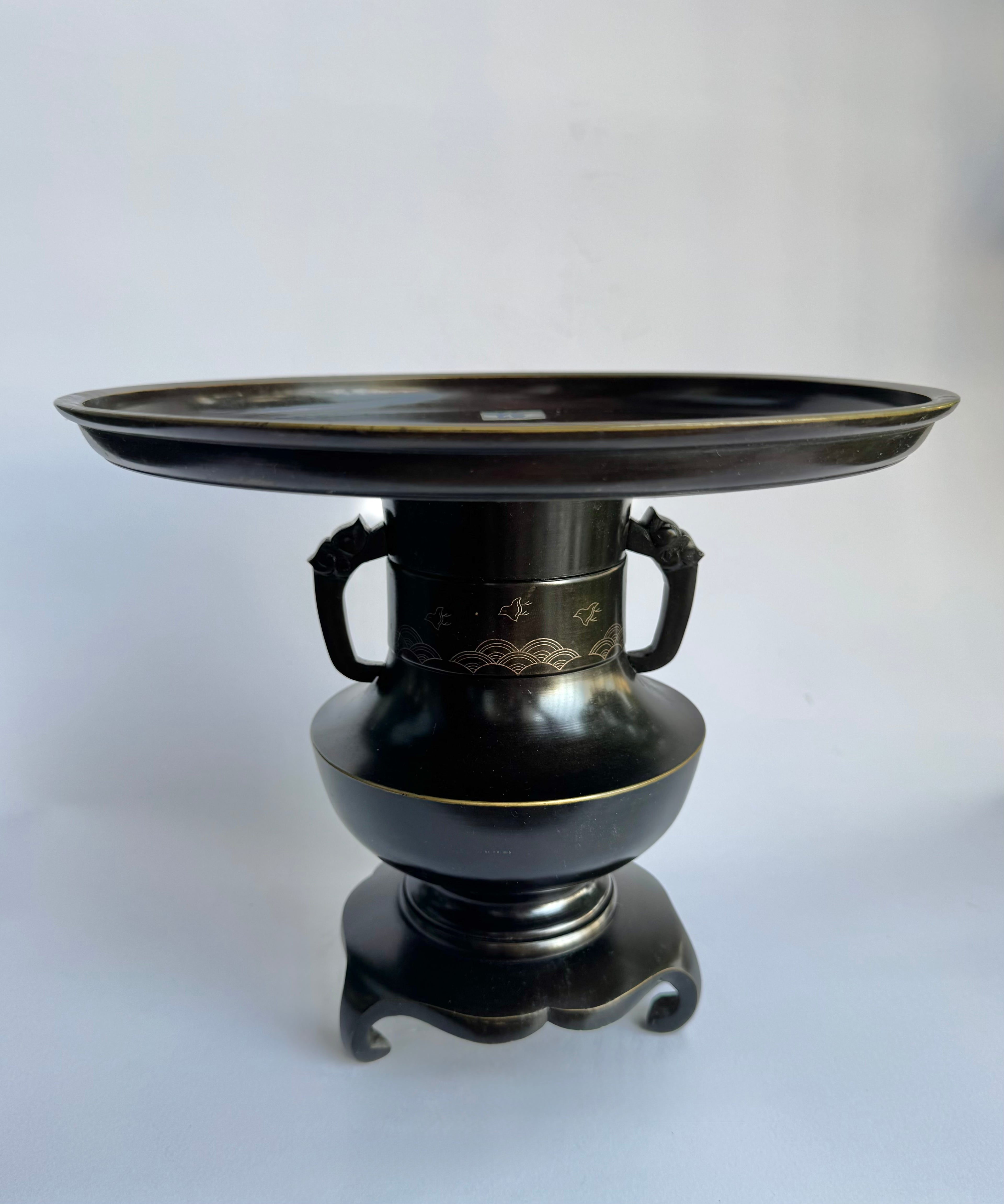 Black decorative urn with a round top on a white background