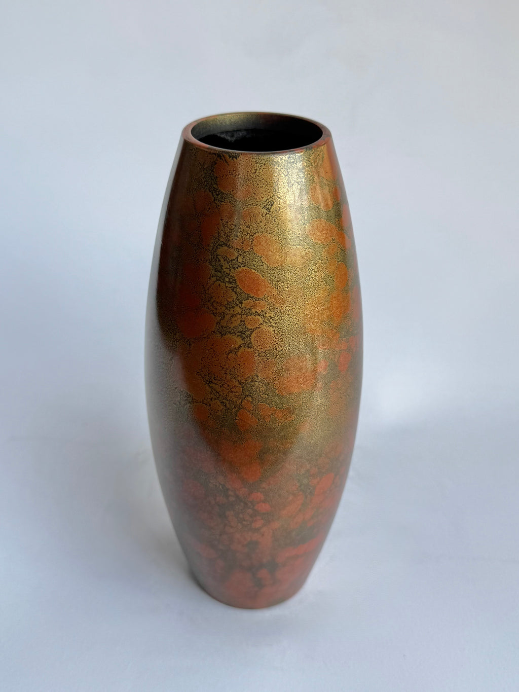 Bronze-colored vase with marbled pattern on a white background