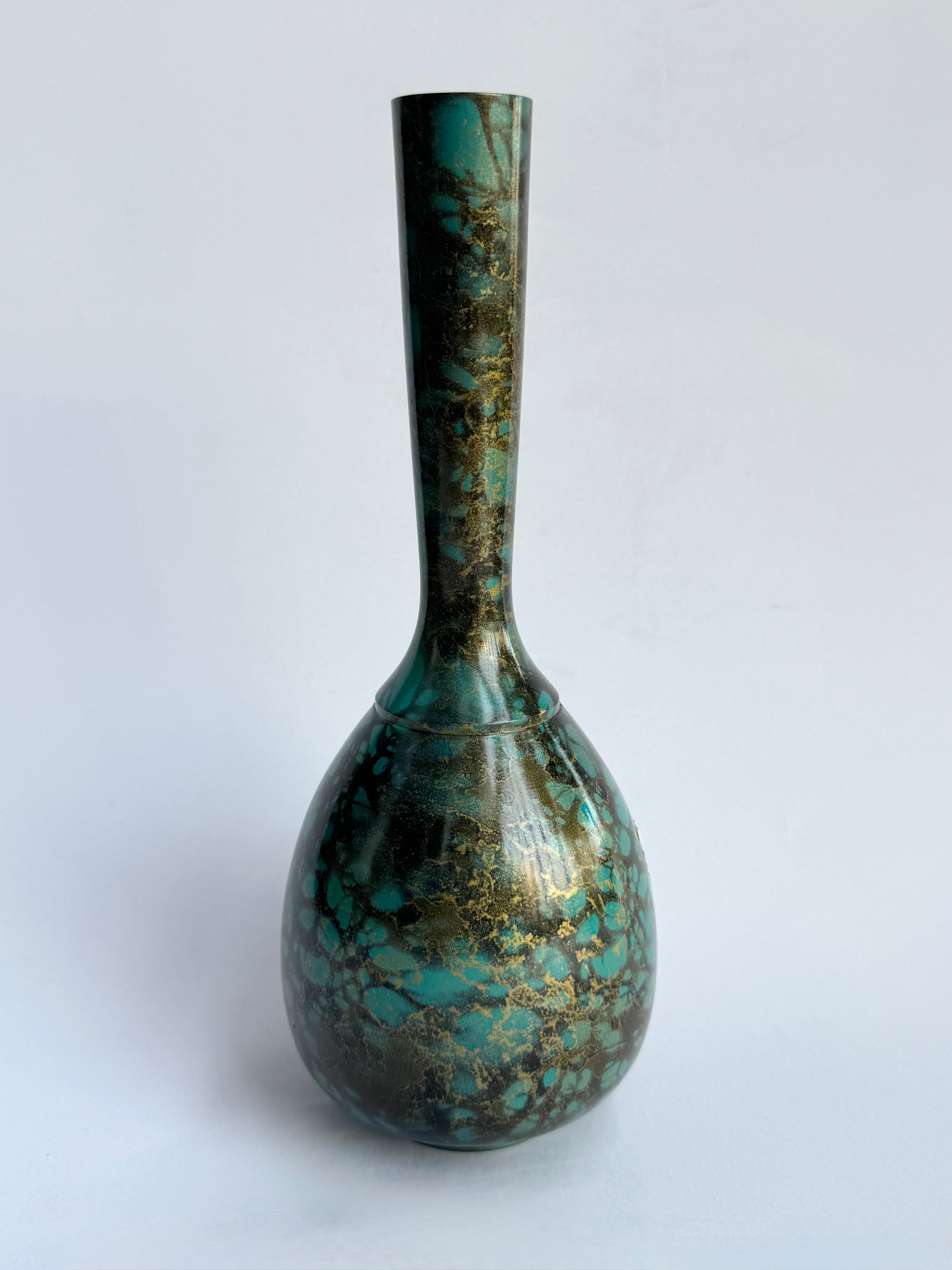 Decorative vase with a textured turquoise and brown design on a white background