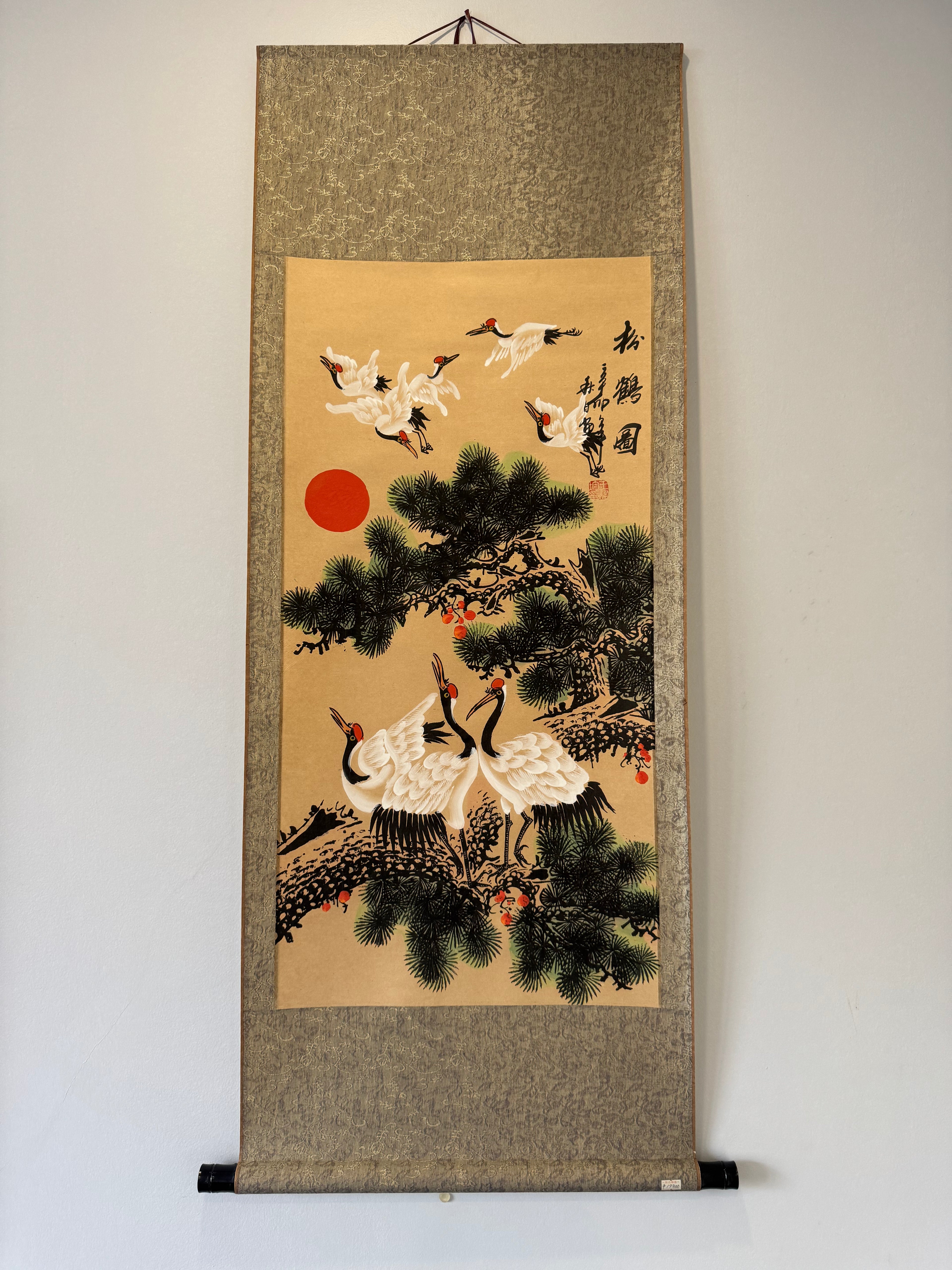 Traditional Chinese scroll art with cranes and pine trees on a beige background