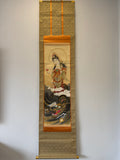 Traditional scroll with a depiction of a figure and dragon on a gold background