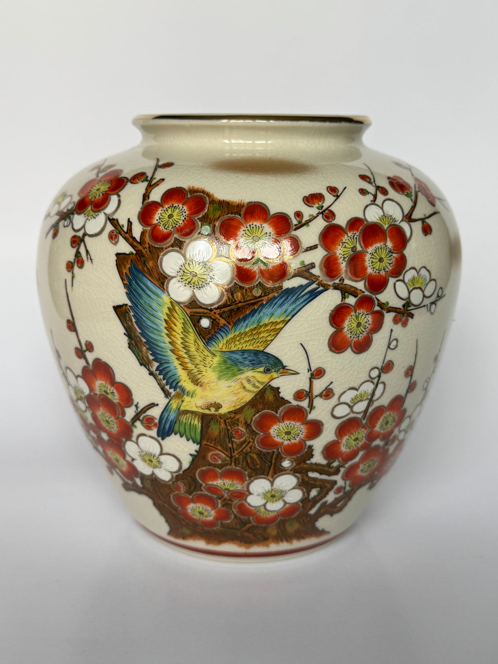 Ceramic vase with floral and bird design on a white background