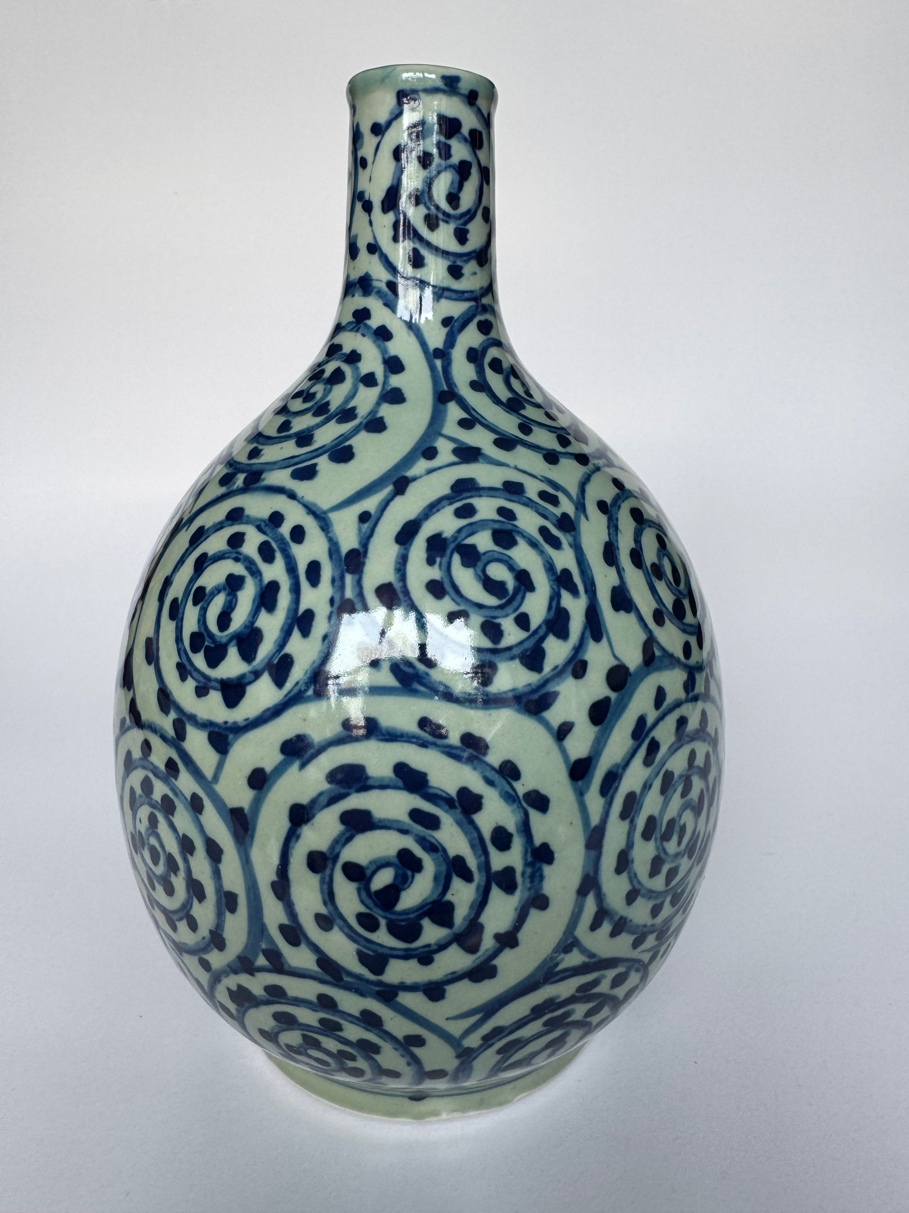 Ceramic vase with blue and white spiral pattern on a white background
