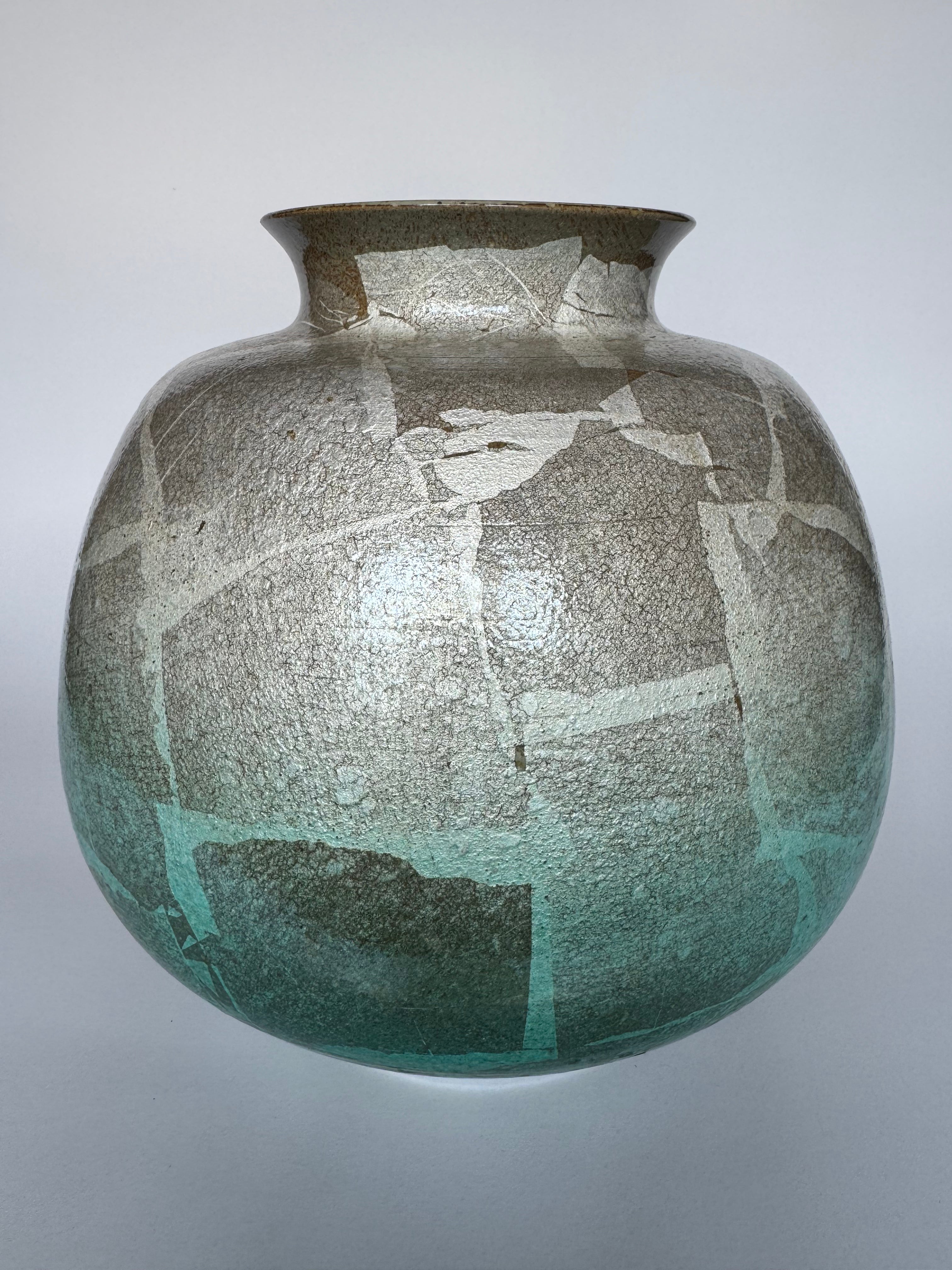 Ceramic vase with textured surface and gradient color on a gray background