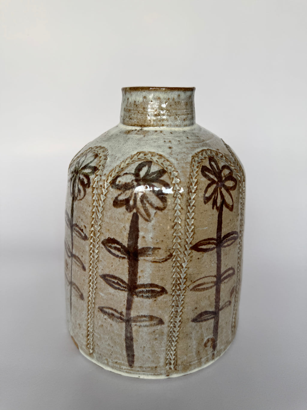 Ceramic vase with brown floral patterns on a white background