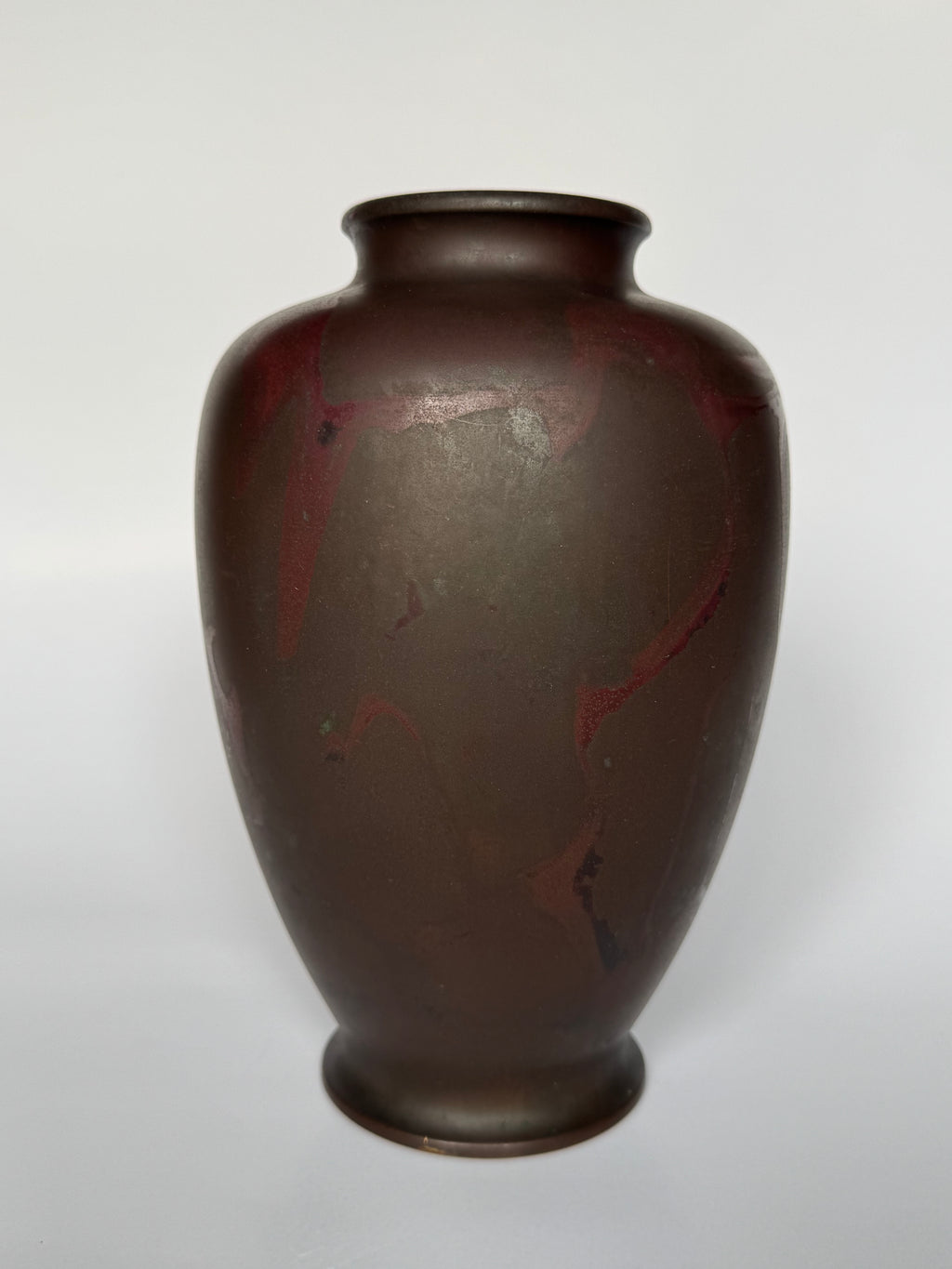 Brown ceramic vase with red accents on a white background