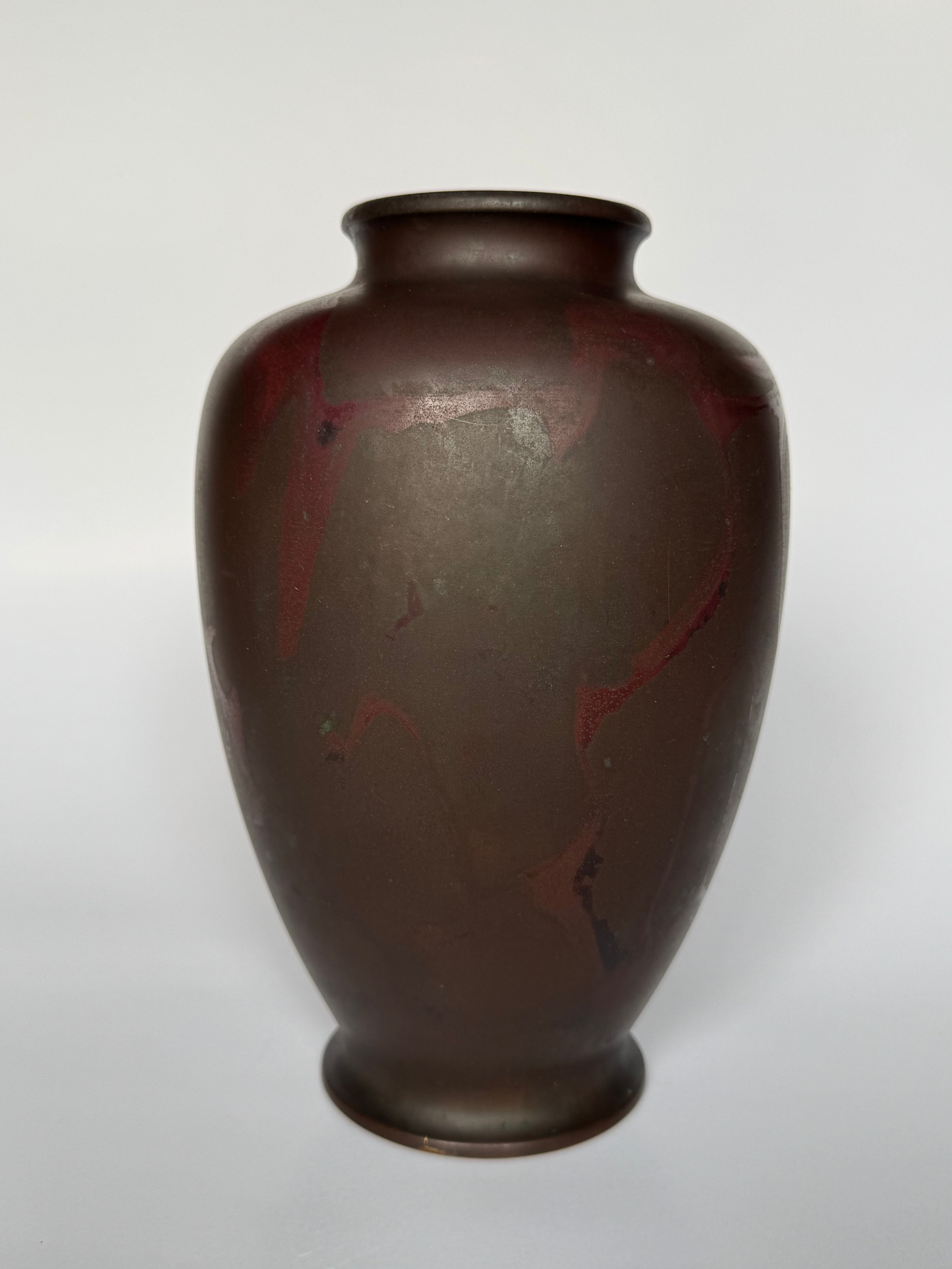 Brown ceramic vase with red accents on a white background