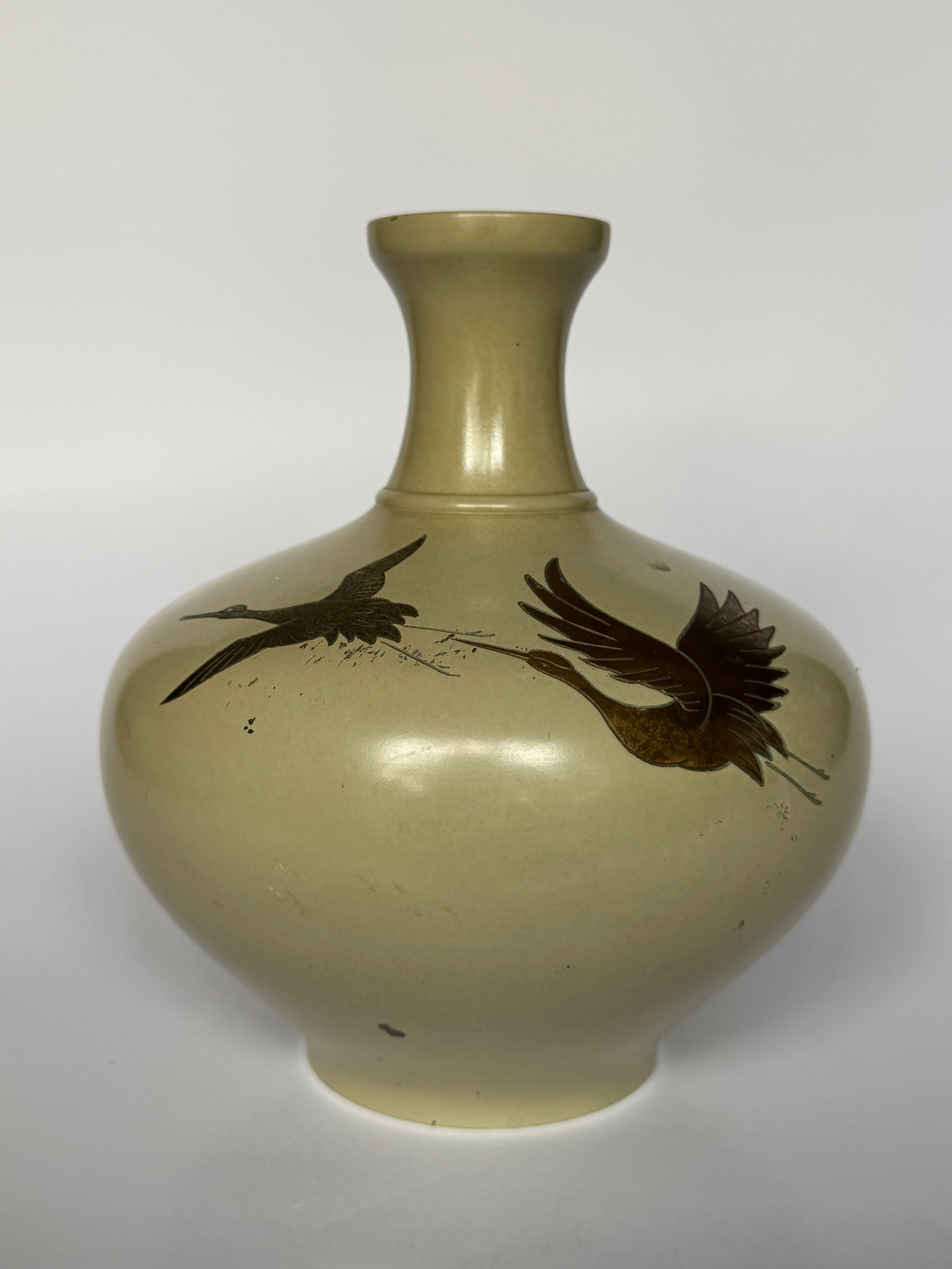 Beige vase with bird designs on a white background