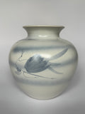 Ceramic vase with butterfly design on a plain background
