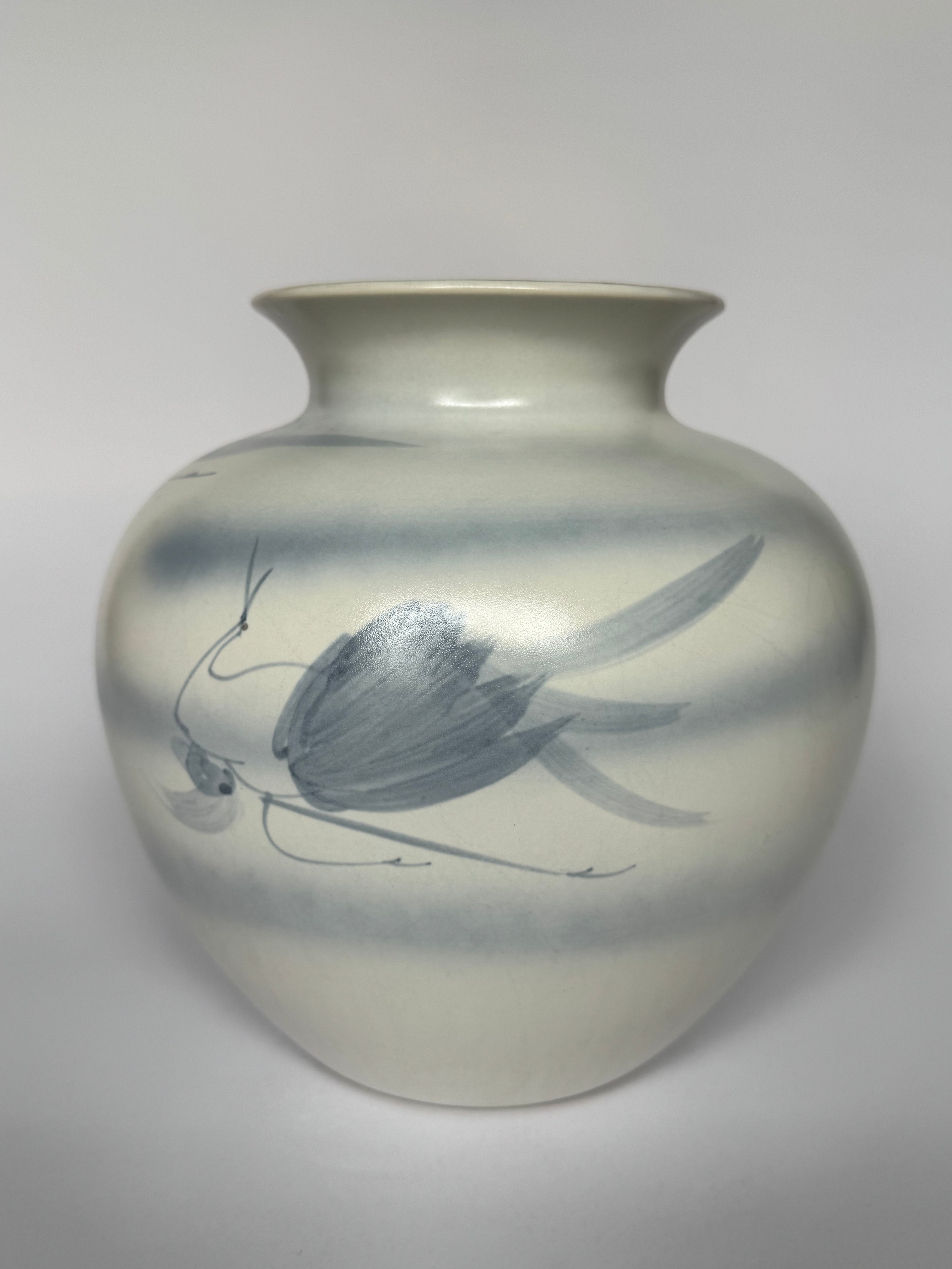 Ceramic vase with butterfly design on a plain background