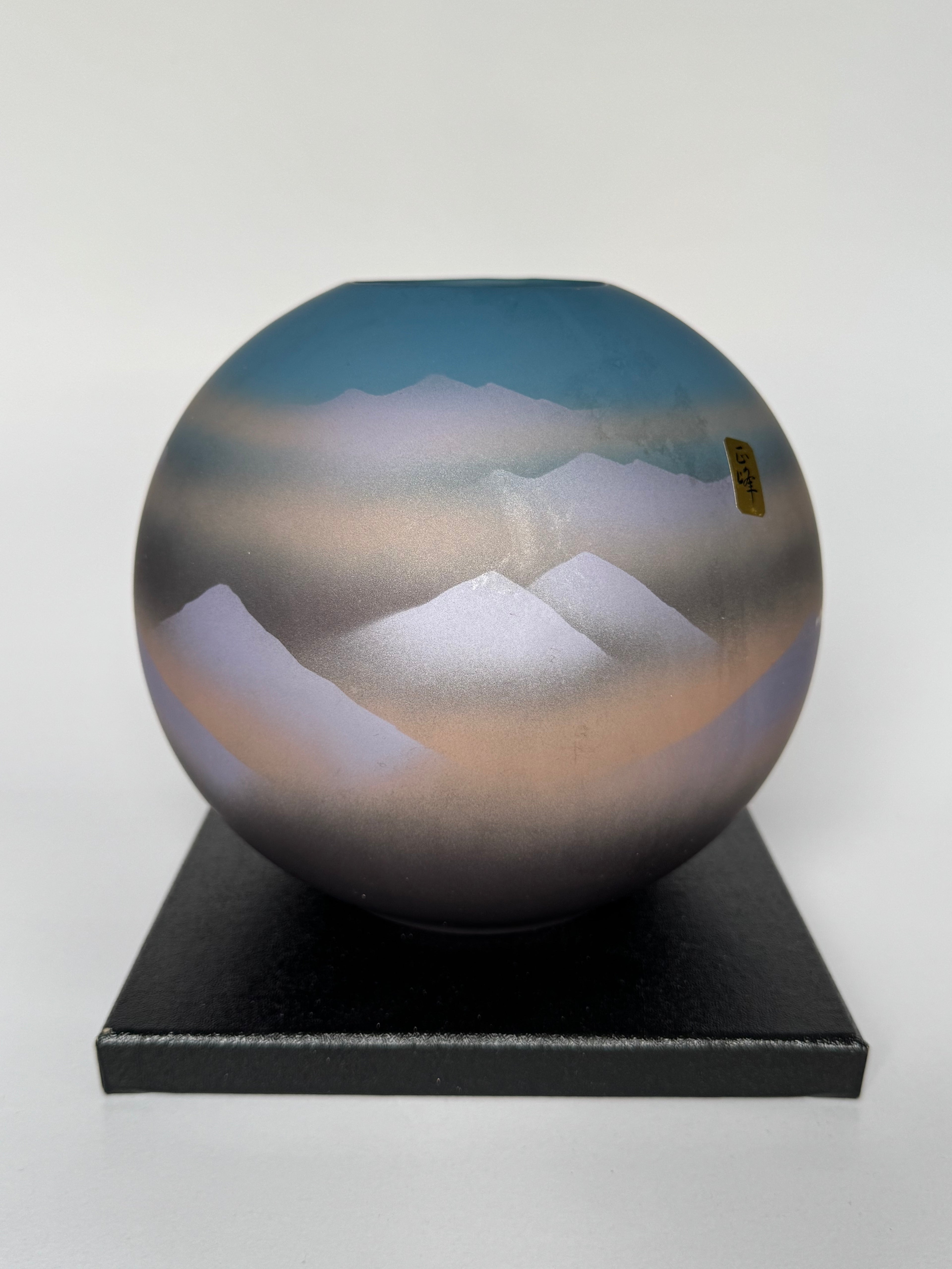 Spherical object with mountain landscape reflection on a white background