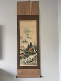 Traditional Japanese landscape painting in a wooden frame on a white wall