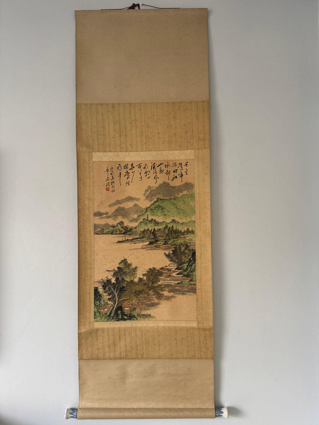 Traditional landscape painting on a vertical scroll with a beige background