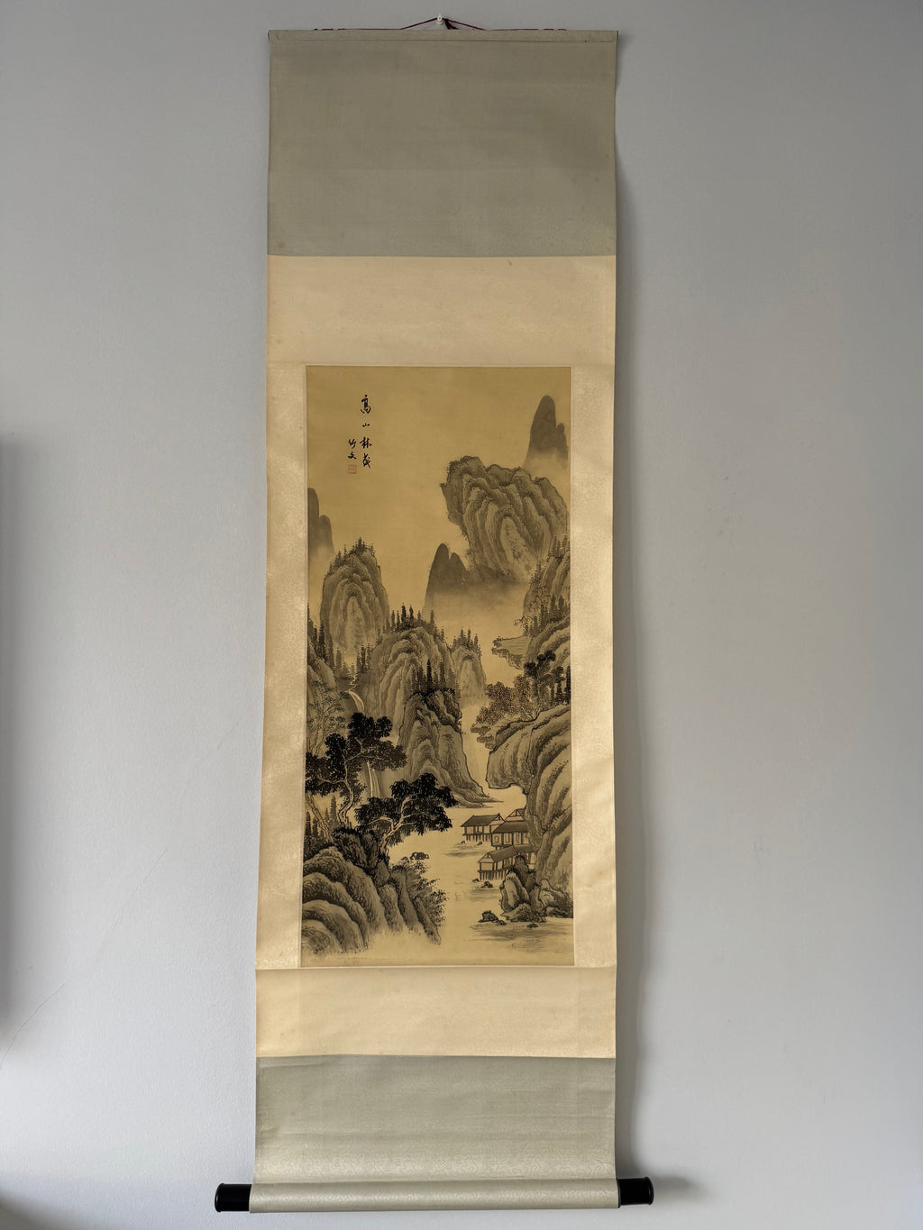 Traditional japanese landscape painting on a vertical scroll against a plain background