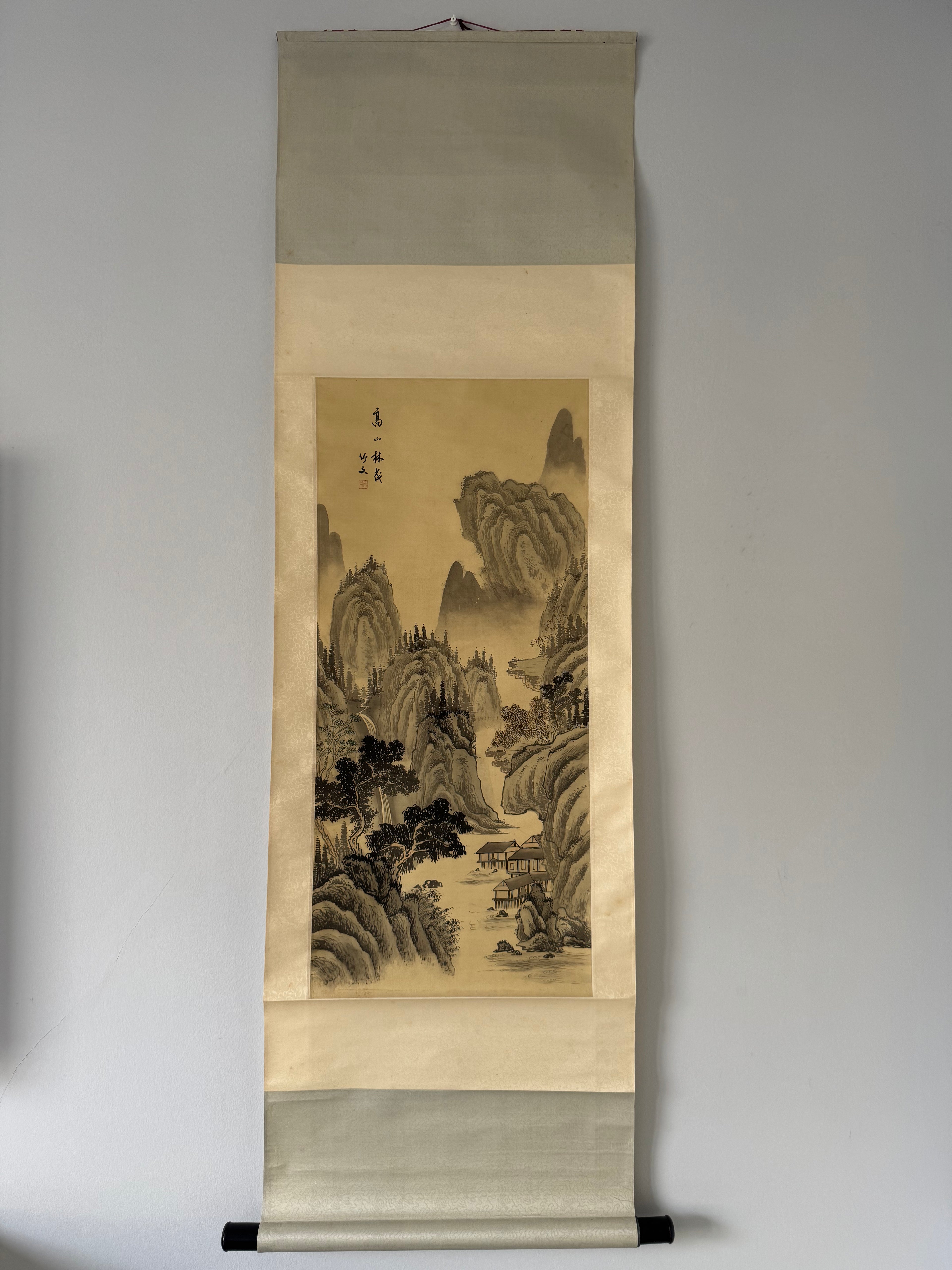 Traditional japanese landscape painting on a vertical scroll against a plain background