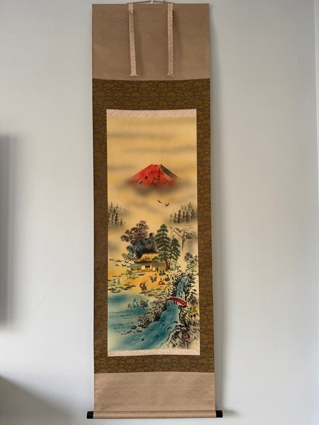 Traditional Japanese landscape scroll with Mount Fuji on a plain wall