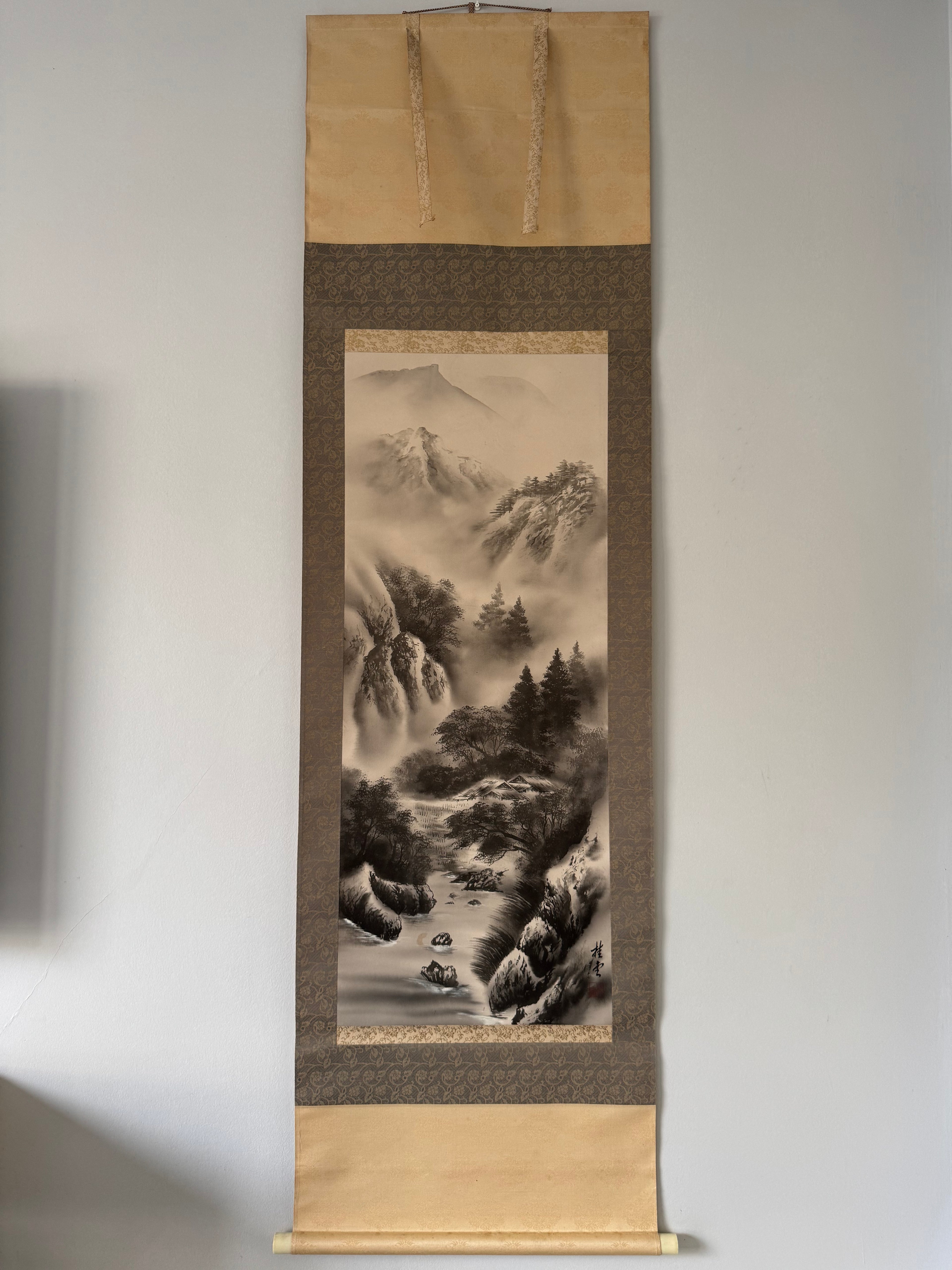 Traditional Japanese landscape scroll on a plain wall