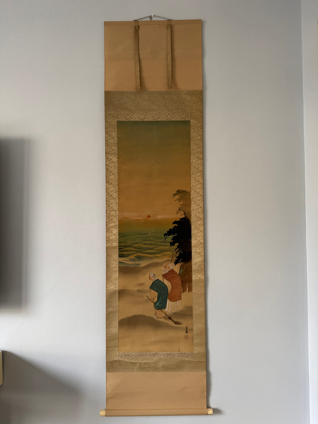 Traditional Japanese scroll painting on a plain wall