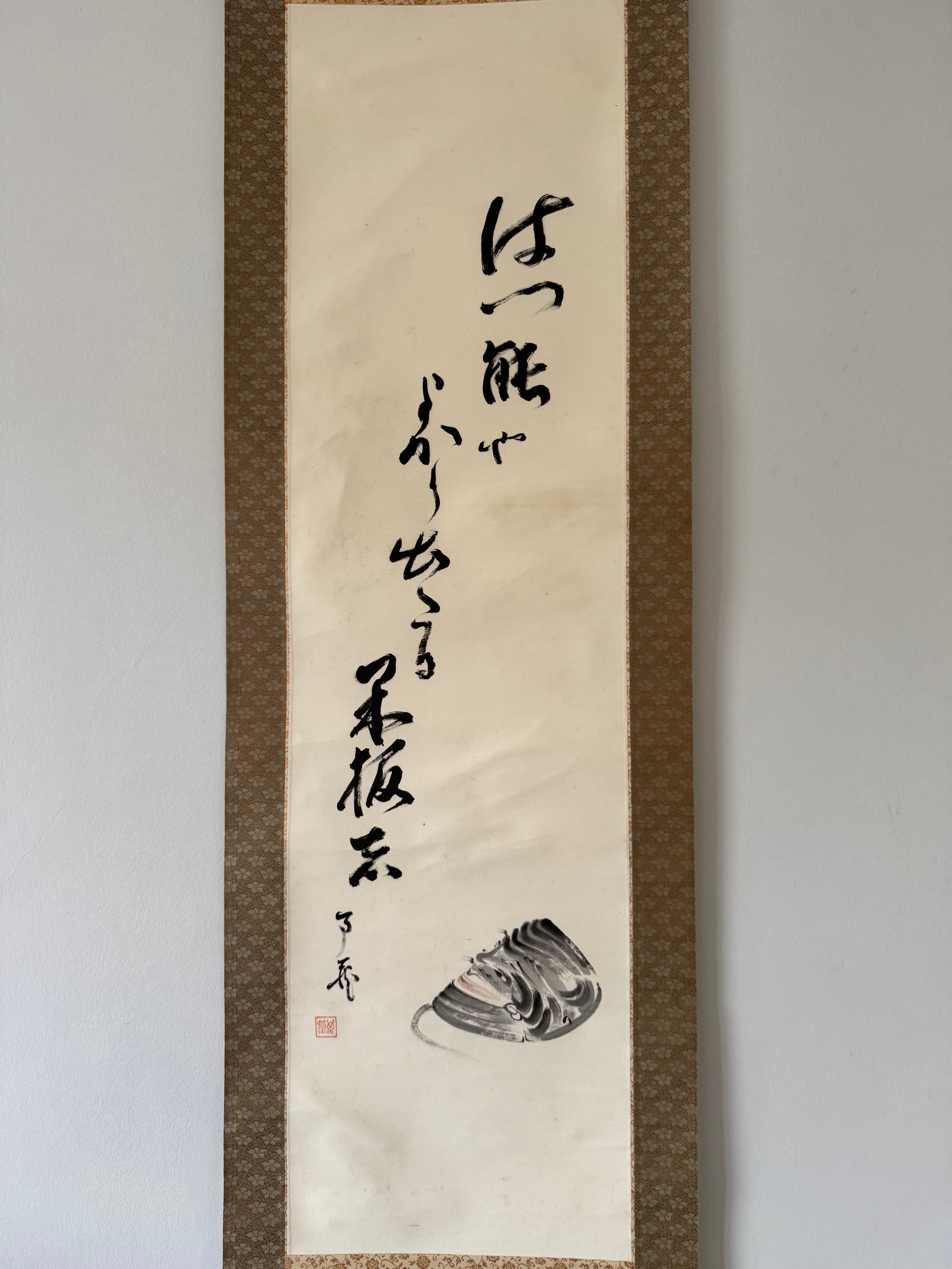 Traditional Japanes calligraphy on a vertical scroll with a decorative border.