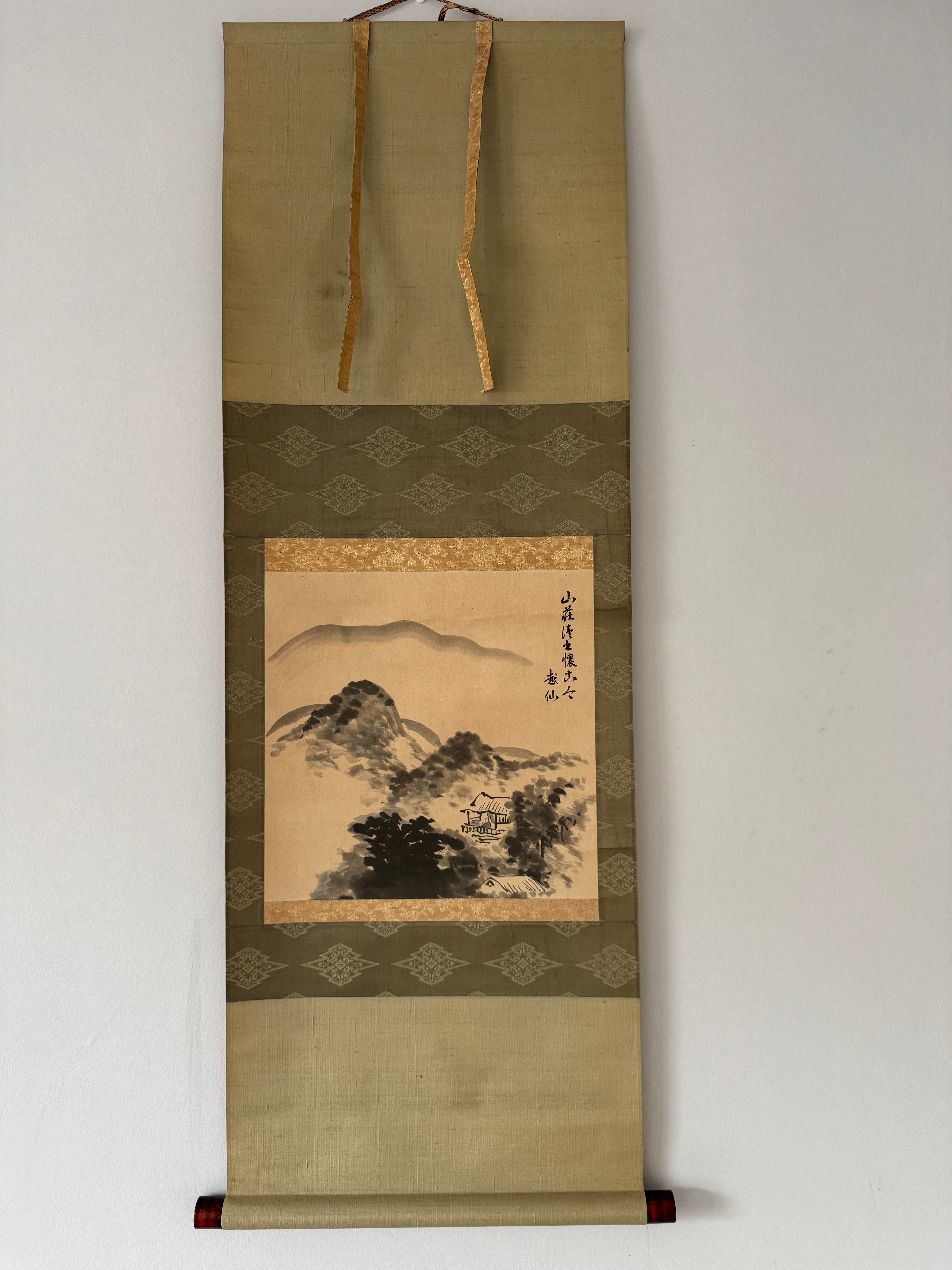 Traditional landscape painting in a decorative scroll frame on a plain background