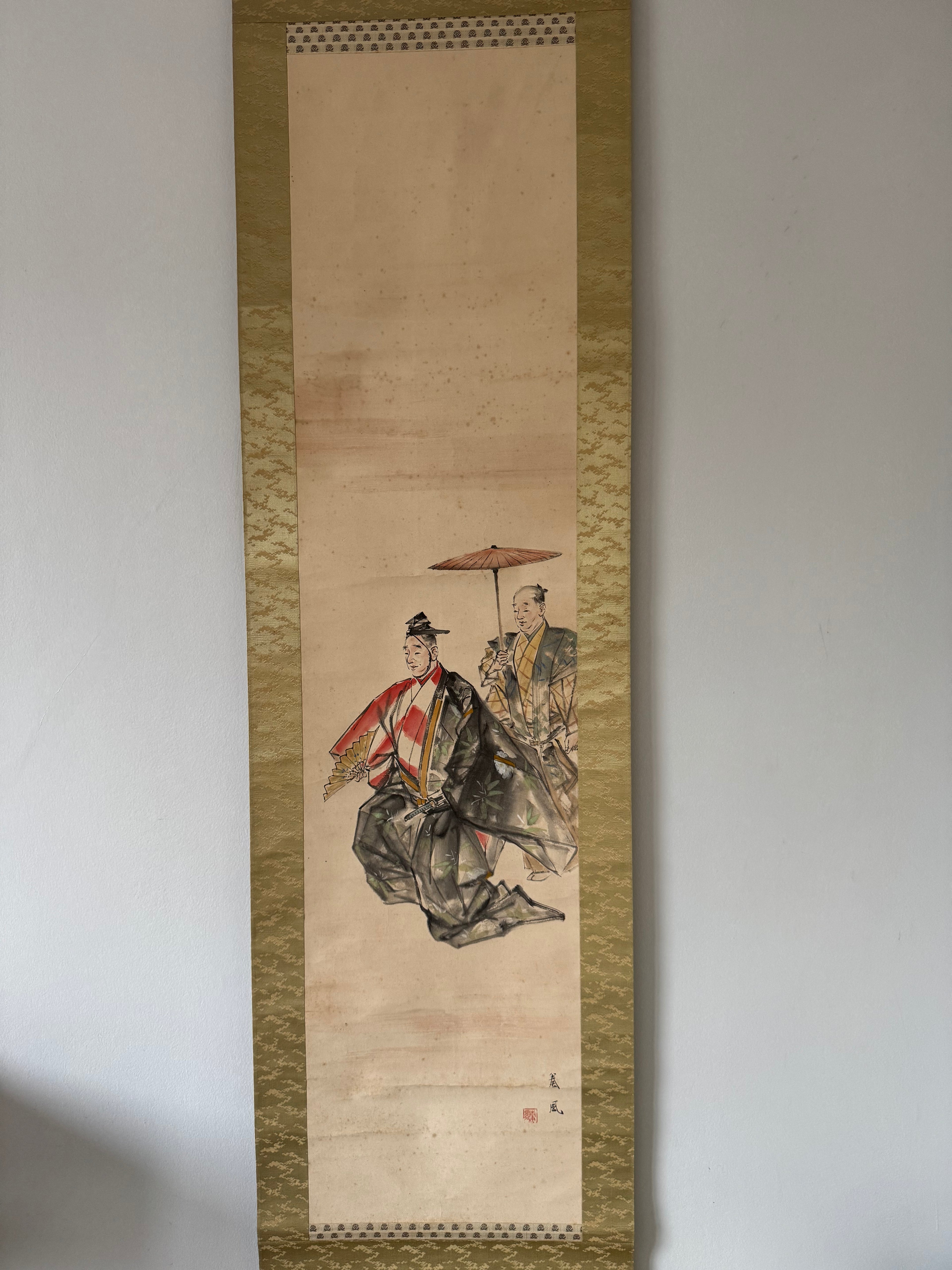 Traditional Japanese artwork on a vertical scroll with a gold border, featuring two figures in formal attire.