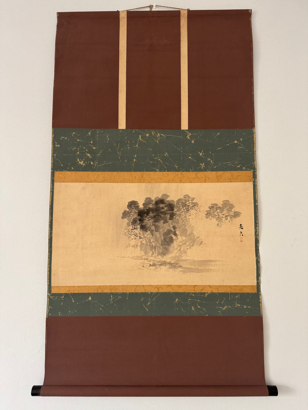 Traditional Japanese scroll with landscape design on a plain background