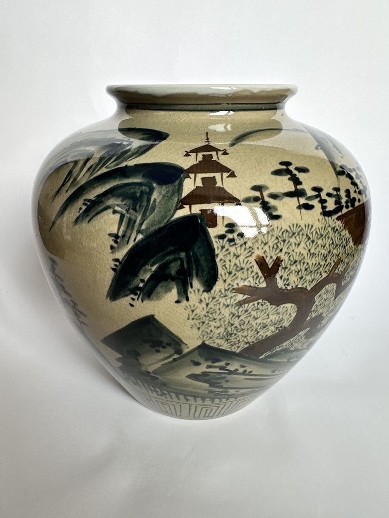 A ceramic garden vase with a rounded body and flared rim, decorated with a hand-painted Japanese landscape scene featuring a pagoda, trees, and mountains in dark green and brown glazes over a warm beige background.