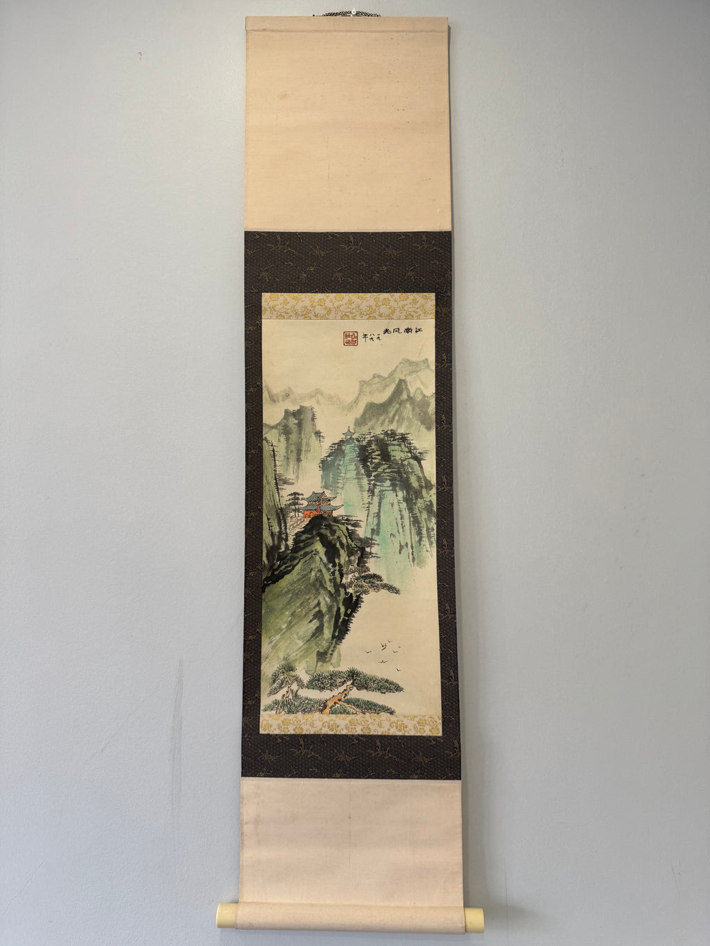 Traditional landscape painting on a vertical scroll against a plain background