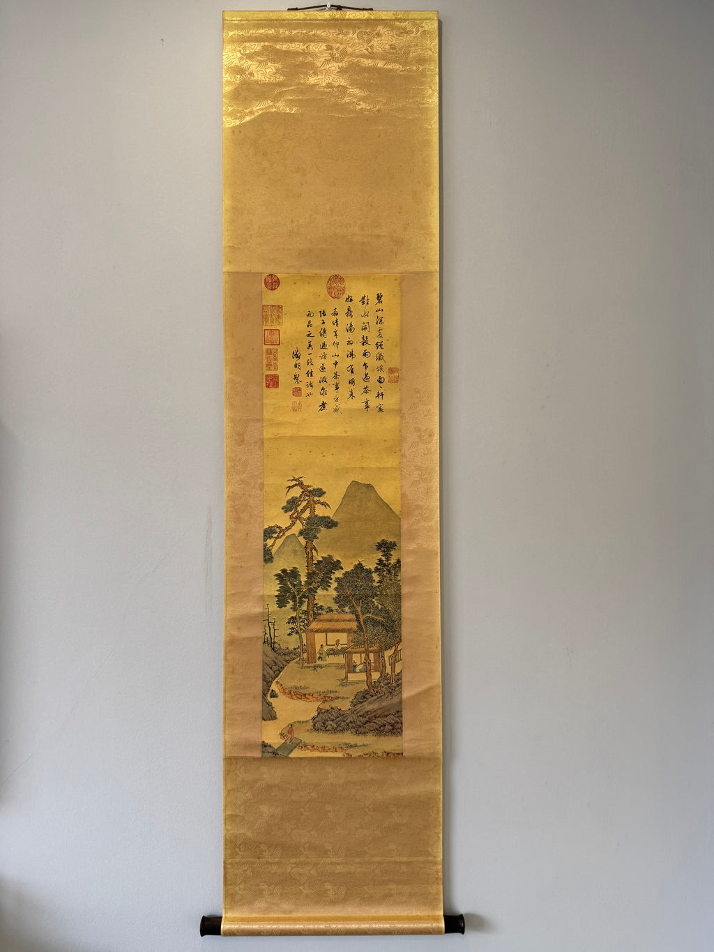 Traditional scroll with landscape and calligraphy on a plain background