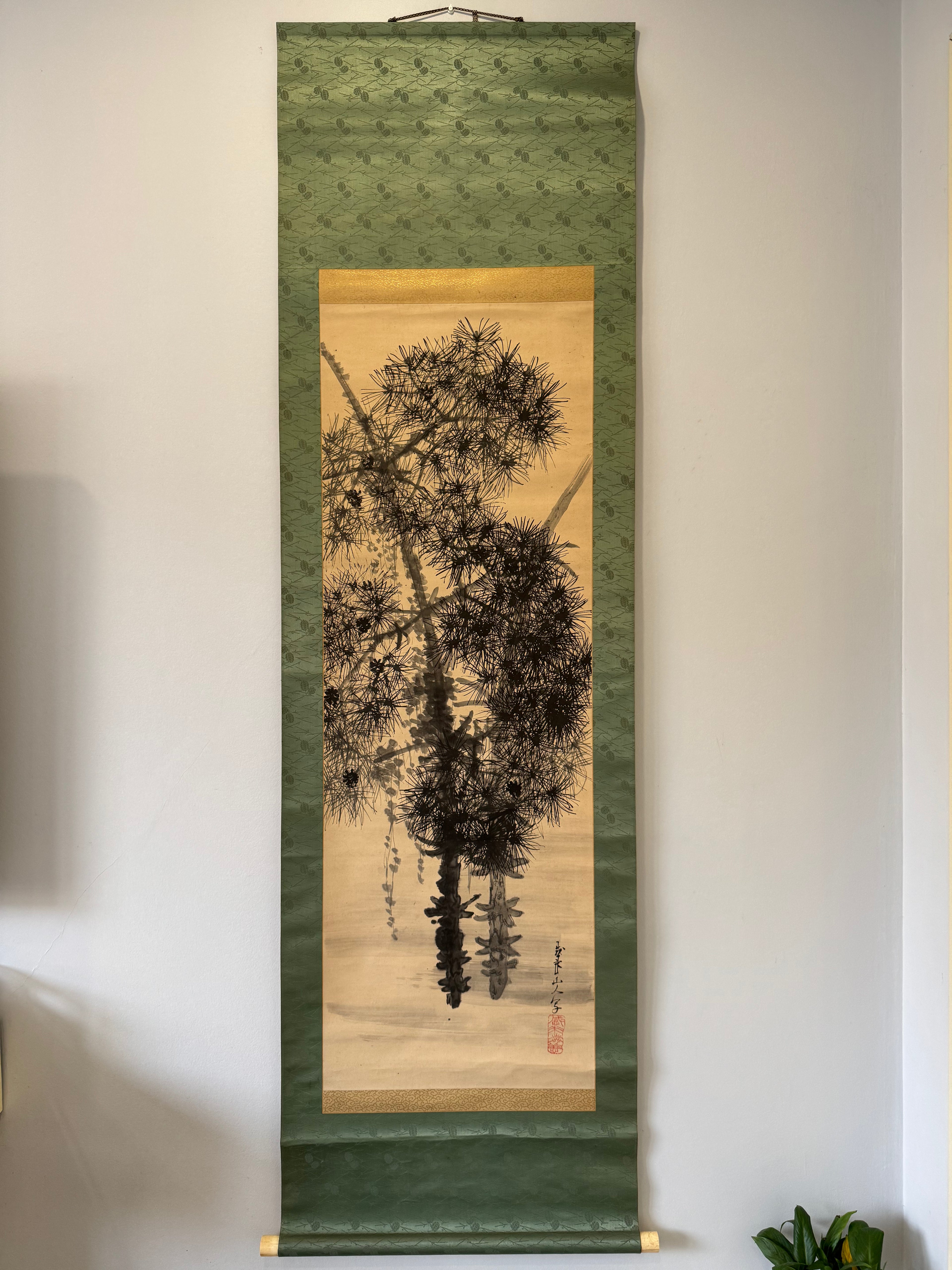 Traditional Japanese scroll with tree design on a green background