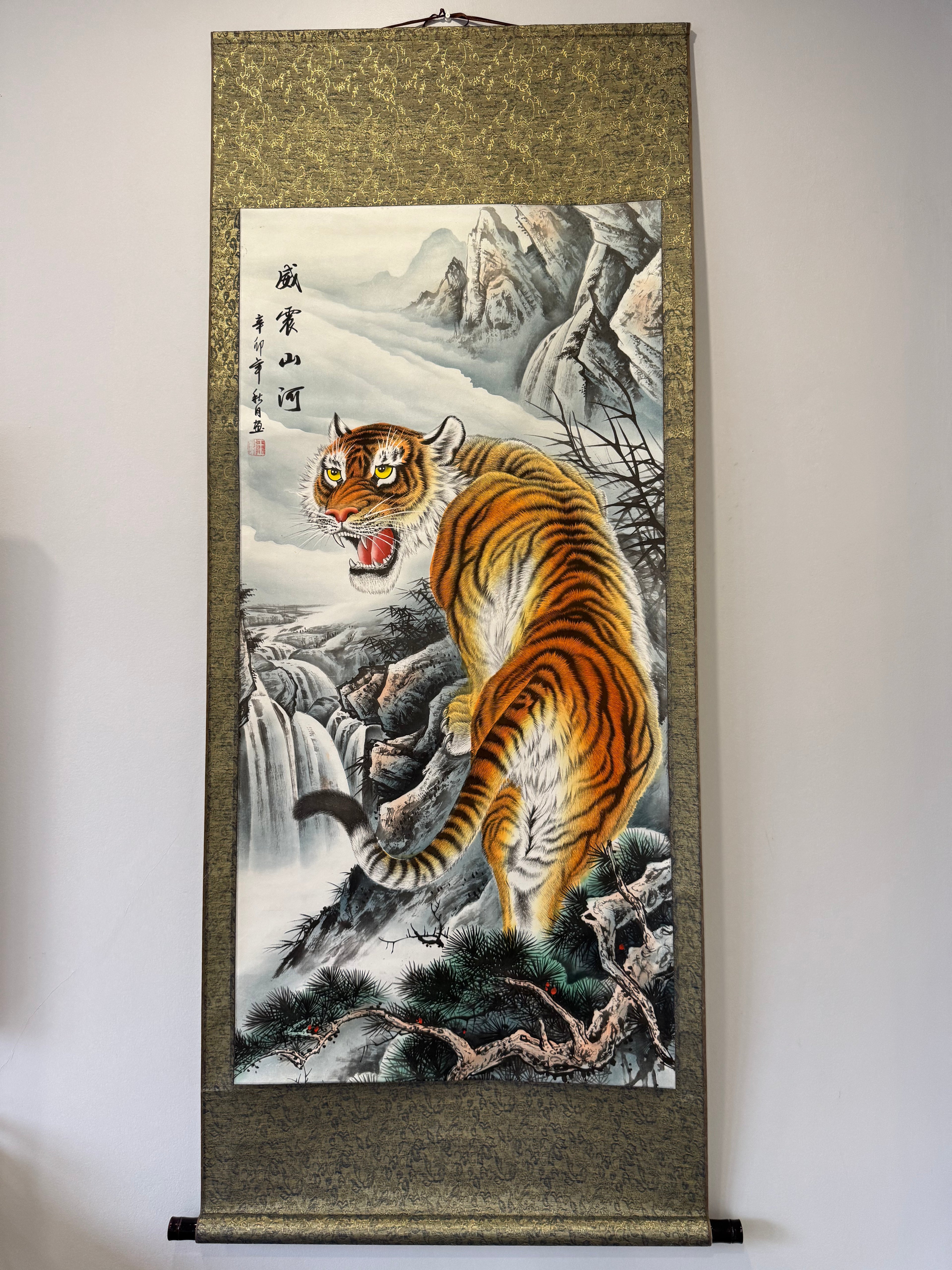Wall scroll with a tiger painting in a mountainous landscape