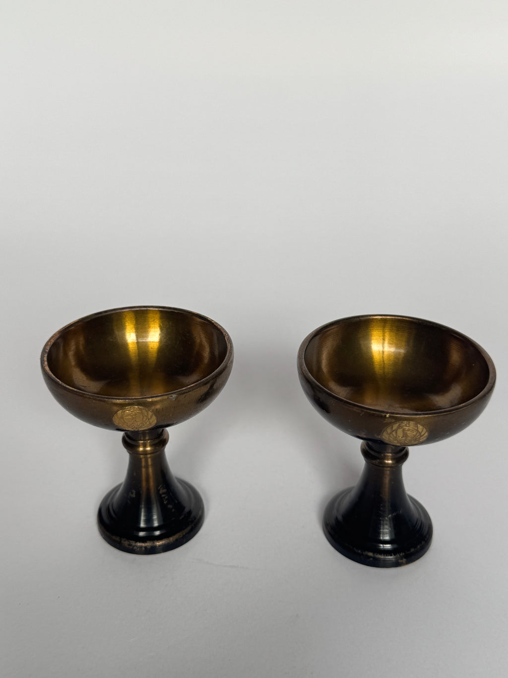 Two bronze bowls on a white background