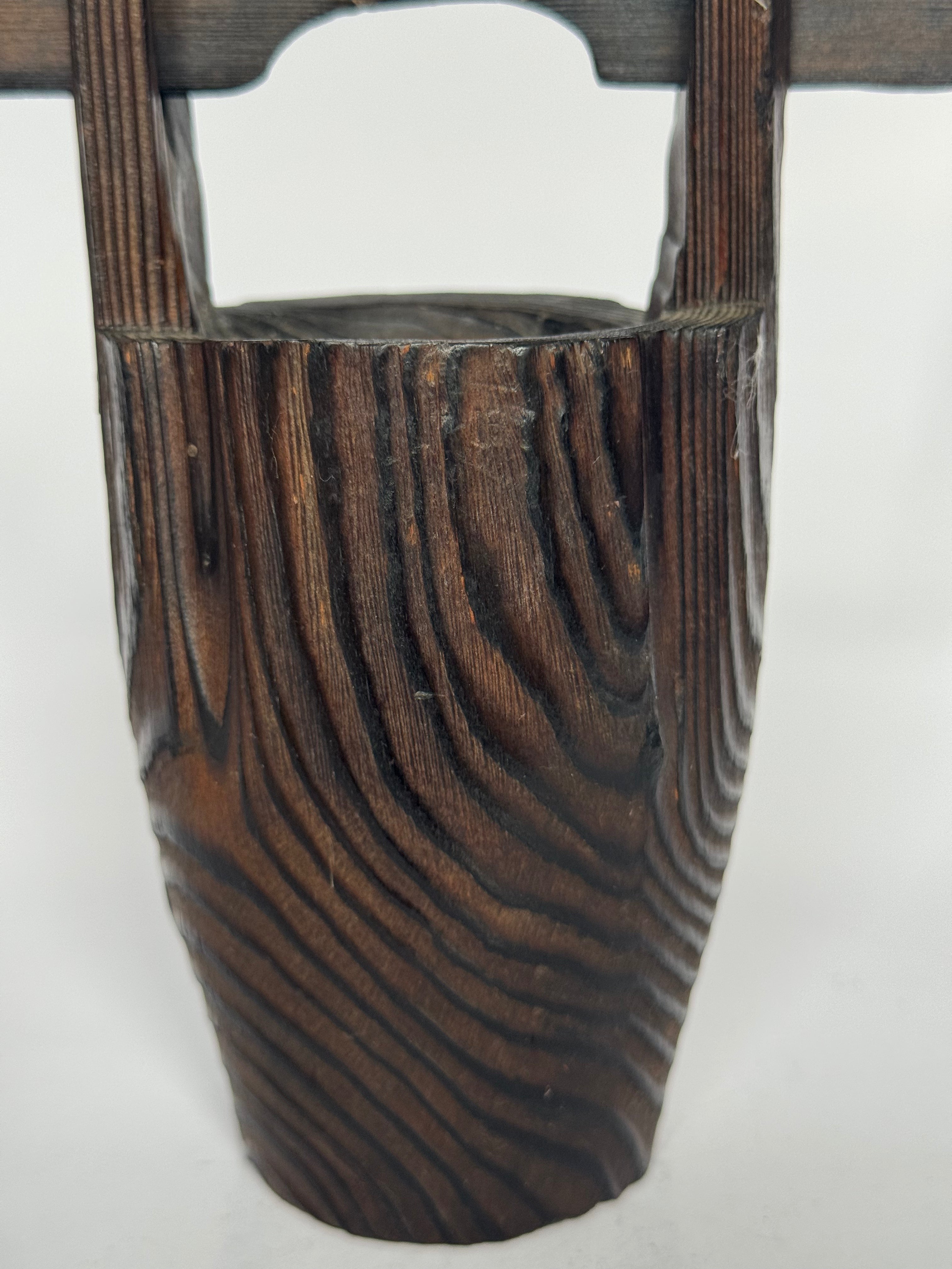 Wooden vase with a textured surface on a white background