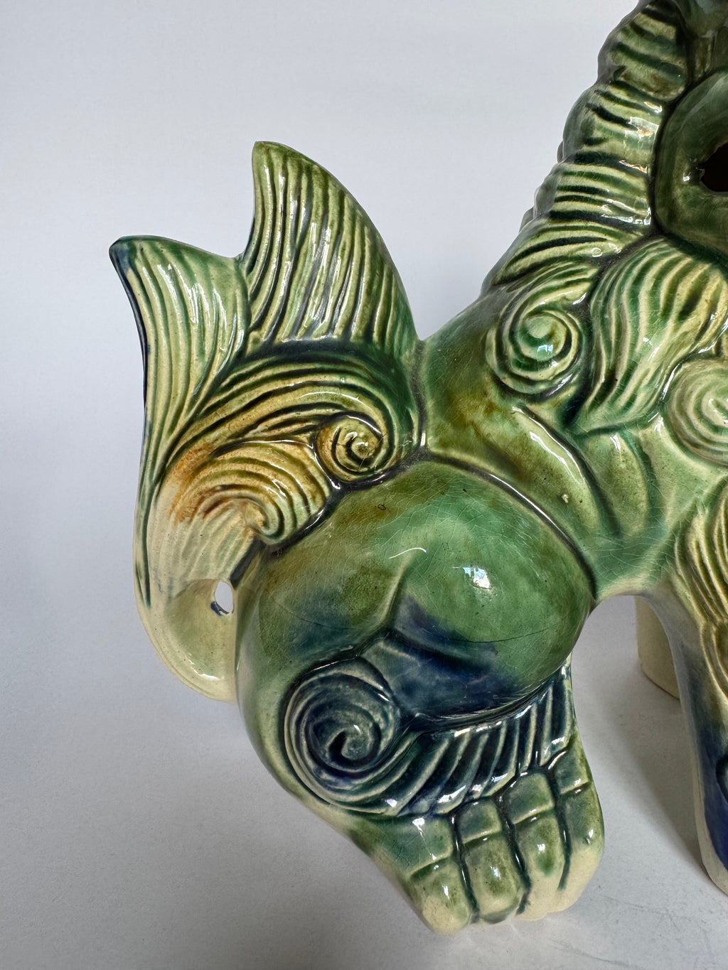 Green ceramic ram head sculpture on a white background