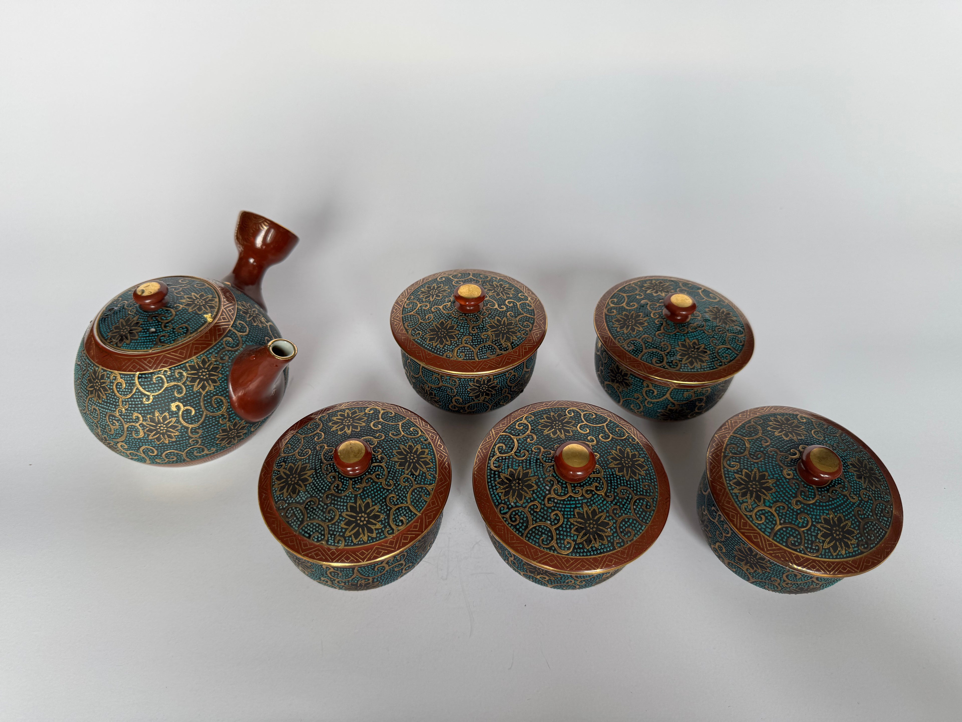Set of six decorative ceramic containers with lids on a white background