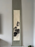 Vertical scroll with landscape painting on a plain wall