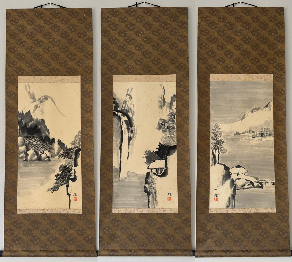 A three-panel traditional Chinese landscape wall scroll set, featuring ink wash paintings of a bird, a mountain scene, and a lakeside pavilion on beige backgrounds with brown patterned borders.