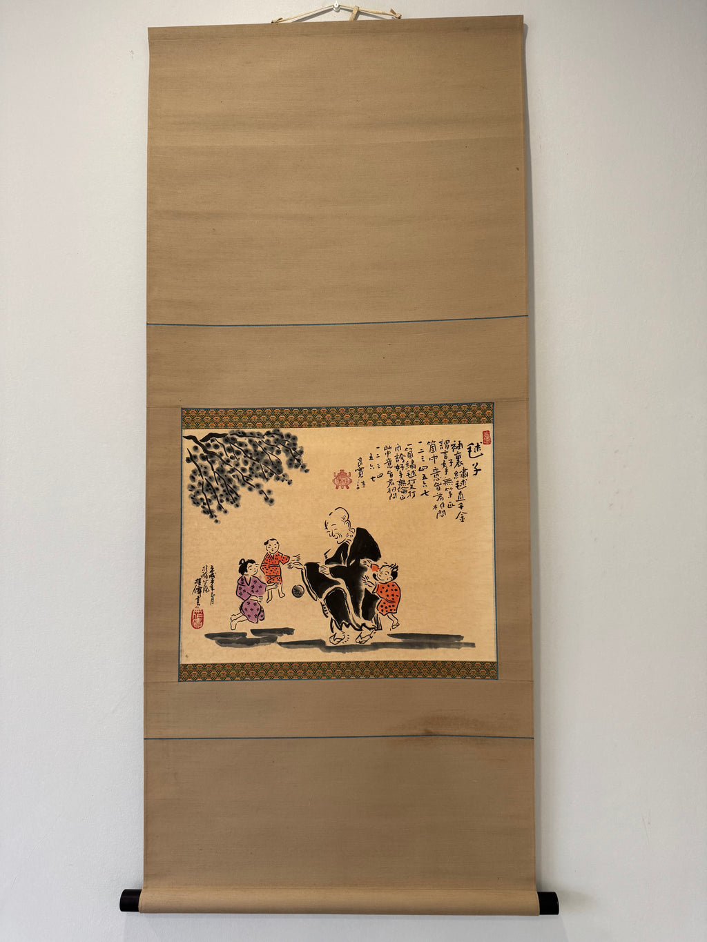 Traditional Japanese scroll with artwork on a plain wall