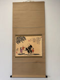 Traditional Japanese scroll with artwork on a plain wall