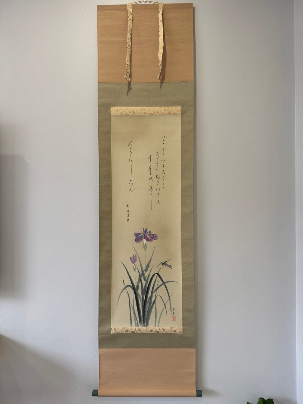 Traditional Japanese scroll with floral design on a plain wall