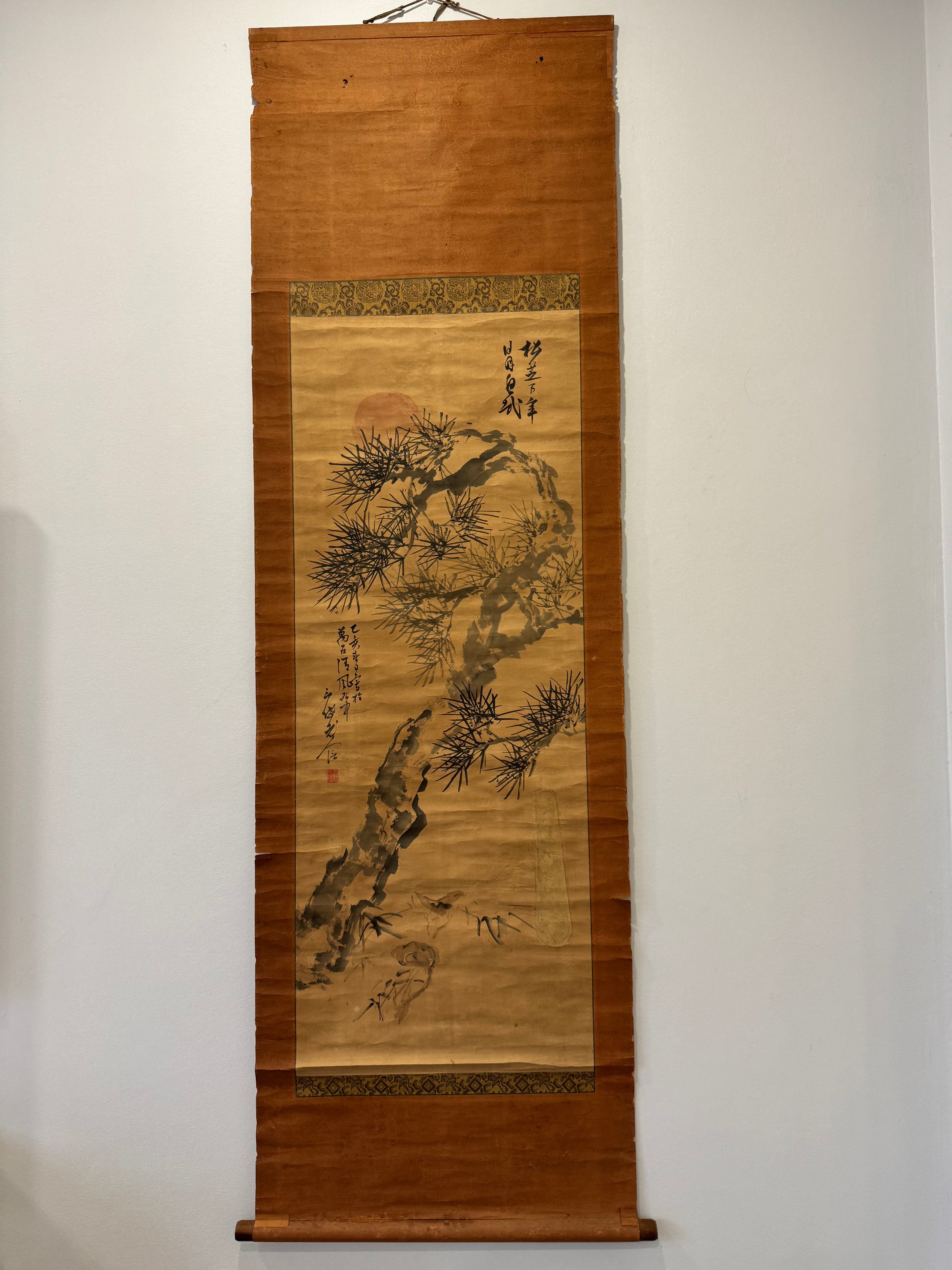 Traditional Japanese scroll with nature-themed artwork on a plain wall