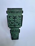 An ornate green decorative wall plaque with intricate carved Chinese-style patterns, photographed against a plain light background.